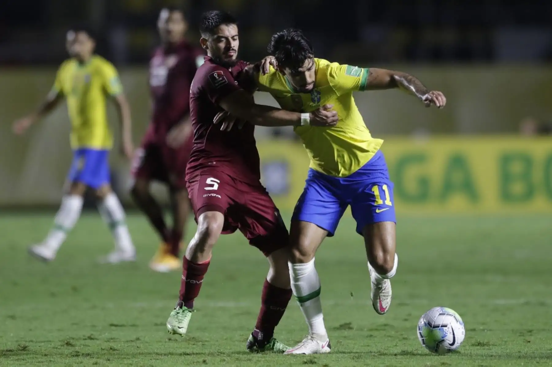 El venezolano Junior Moreno (izq.) y el brasileño Lucas Paqueta compiten por el balón durante su partido de fútbol a puerta cerrada clasificatorio sudamericano para la Copa Mundial de la FIFA 2022 en el Estadio Morumbi en Sao Paulo, Brasil. Foto: AFP