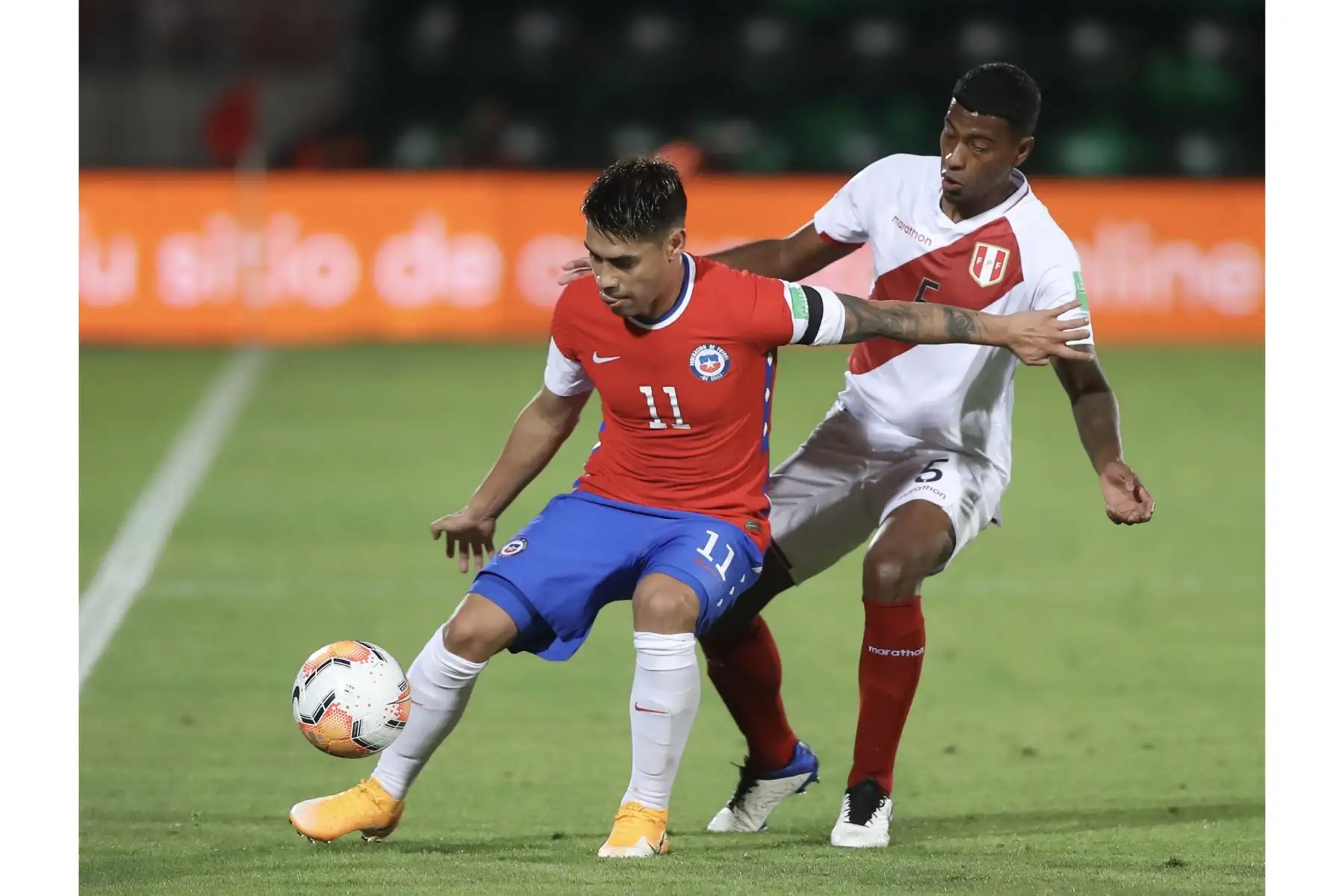 Miguel Araujo de la Selección peruana lucha por el balón ante su rival chileno durante partido por las Clasificatorias Qatar 2022. Foto: FPF
