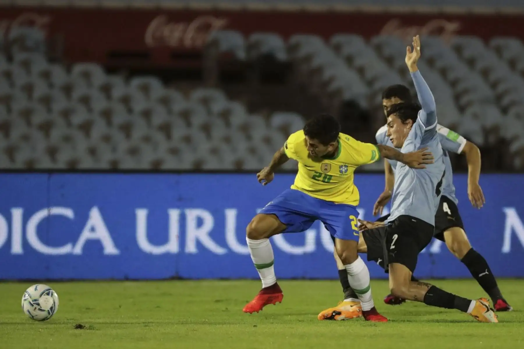 El brasileño Roberto Firmino (izq.) Y el uruguayo José María Giménez compiten por el balón durante el partido a puerta cerrada clasificatorio sudamericano para la Copa Mundial de la FIFA 2022 en el Estadio Centenario de Montevideo. Foto: AFP