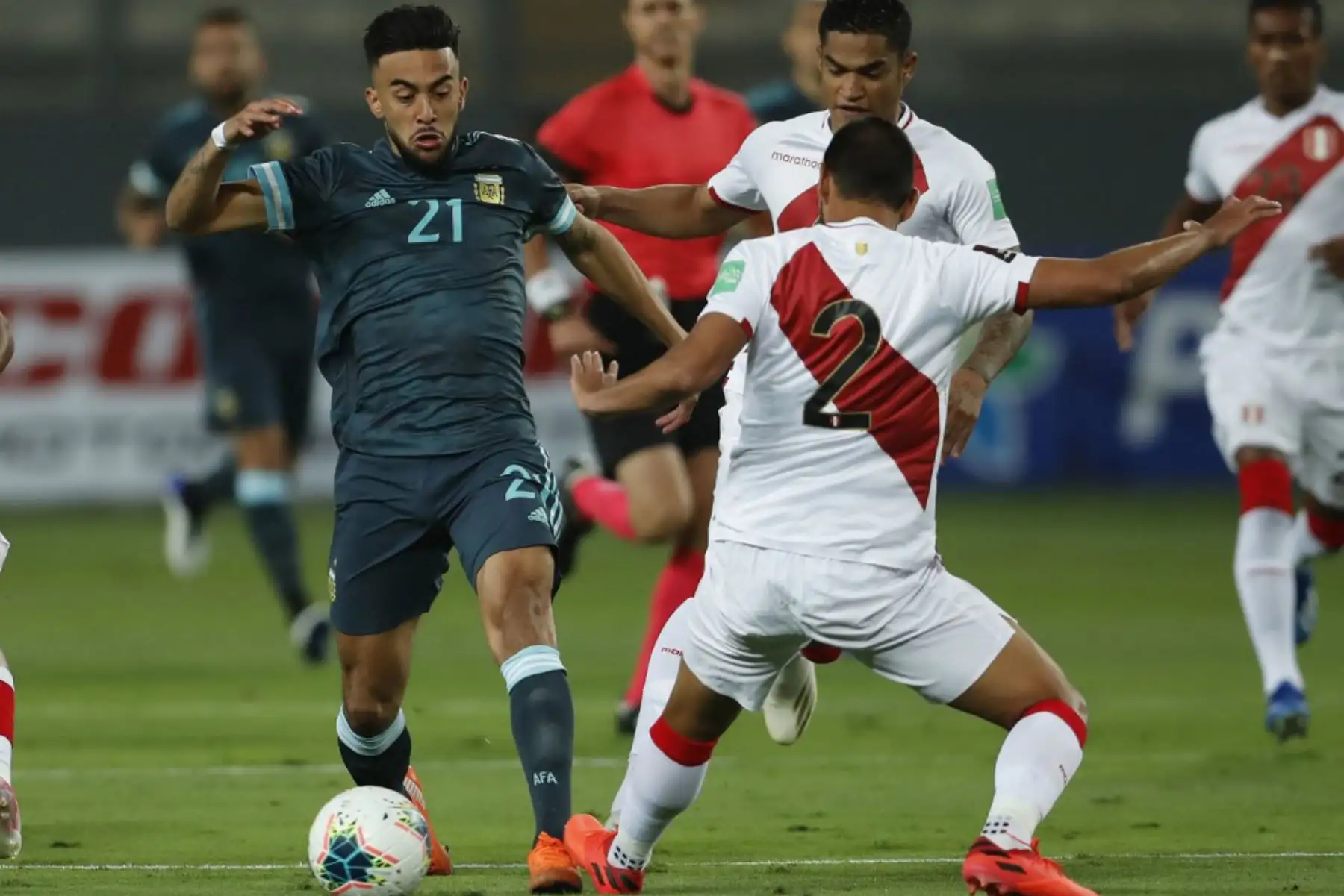 El argentino Nicolás González y el peruano Luis Abram compiten por el balón durante su partido de fútbol a puerta cerrada clasificatorio sudamericano para la Copa Mundial de la FIFA 2022 en el Estadio Nacional de Lima. Foto: AFP