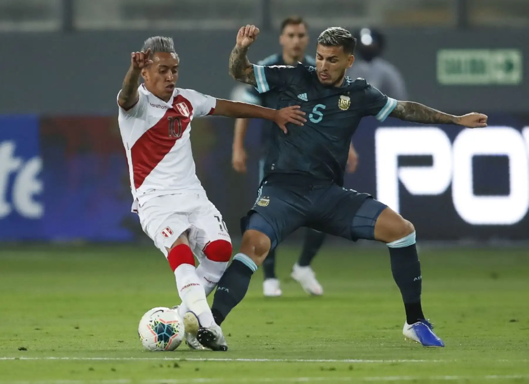 El peruano Christian Cueva (izq.) Y el argentino Leandro Paredes compiten por el balón durante su partido de fútbol a puerta cerrada clasificatorio sudamericano para la Copa Mundial de la FIFA 2022 en el Estadio Nacional de Lima. Foto: AFP