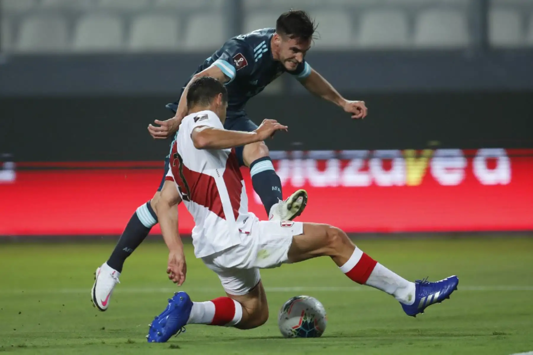 El argentino Nicolás Tagliafico  y el peruano Aldo Corzo compiten por el balón durante su partido de fútbol a puerta cerrada clasificatorio sudamericano para la Copa Mundial de la FIFA 2022 en el Estadio Nacional. Foto: AFP