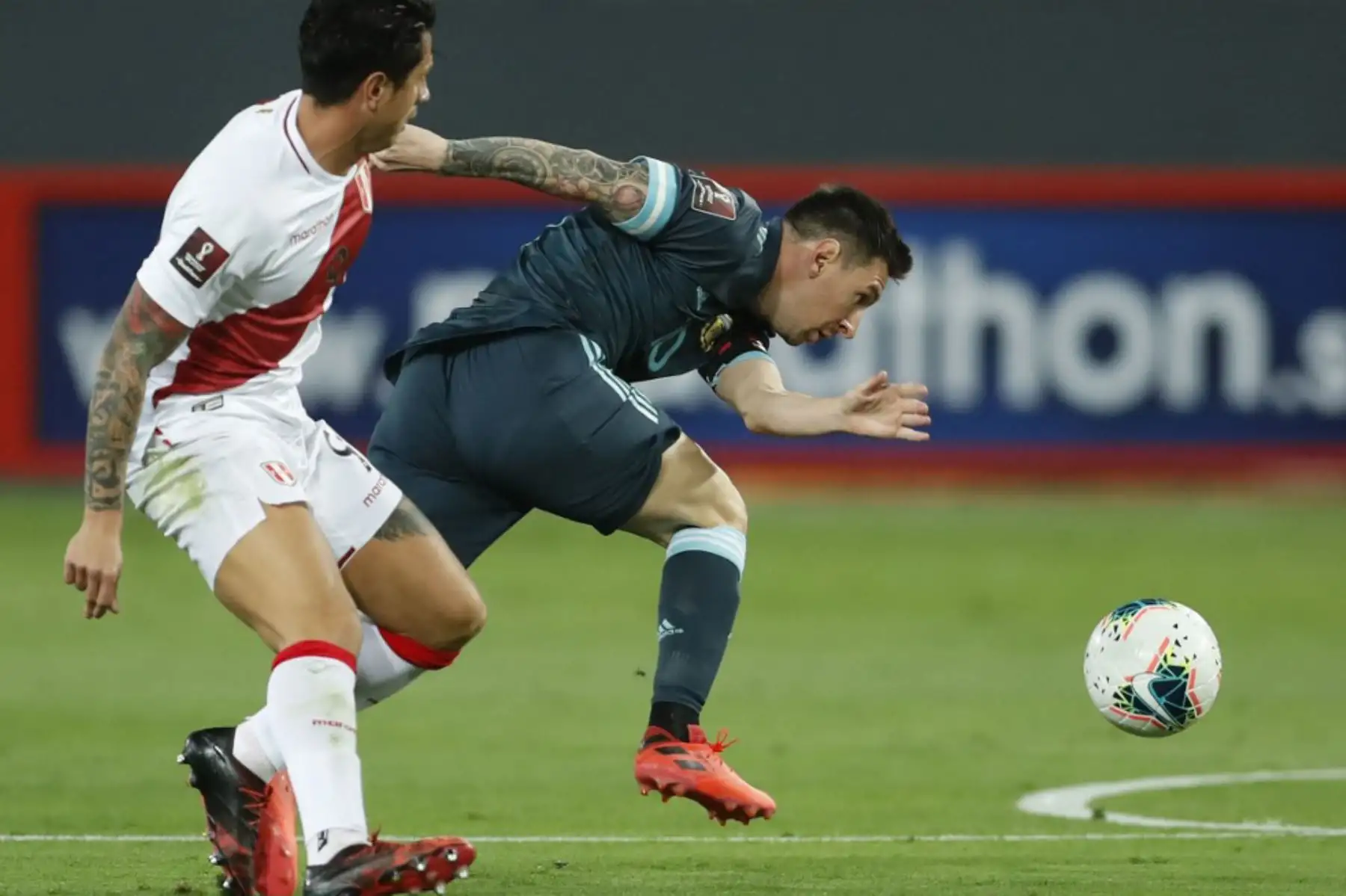 El argentino Lionel Messi  y el peruano Gianluca Lapadula compiten por el balón durante su partido de fútbol a puerta cerrada clasificatorio sudamericano para la Copa Mundial de la FIFA 2022 en el Estadio Nacional. Foto. AFP