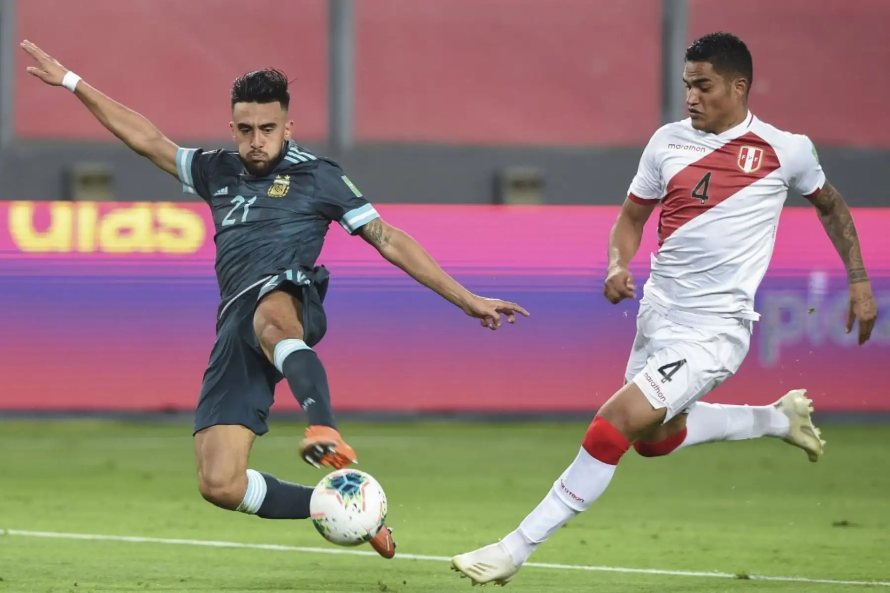 El argentino Nicolás González (izq.) Y el peruano Anderson Santamaría compiten por el balón durante su partido de fútbol a puerta cerrada clasificatorio sudamericano para la Copa Mundial de la FIFA 2022 en el Estadio Nacional de Lima. Foto: AFP