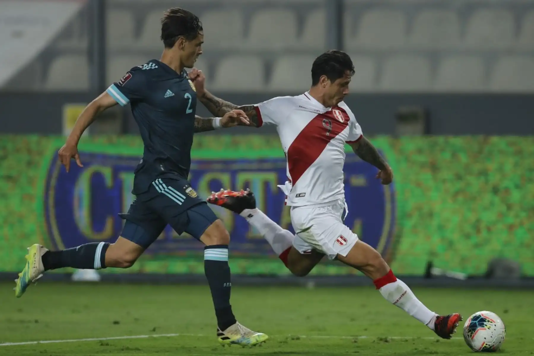El peruano Gianluca Lapadula (derecha) es desafiado por el argentino Lucas Martínez Quarta durante su partido de fútbol a puerta cerrada clasificatorio sudamericano para la Copa Mundial de la FIFA 2022 en el Estadio Nacional de Lima. Foto: AFP