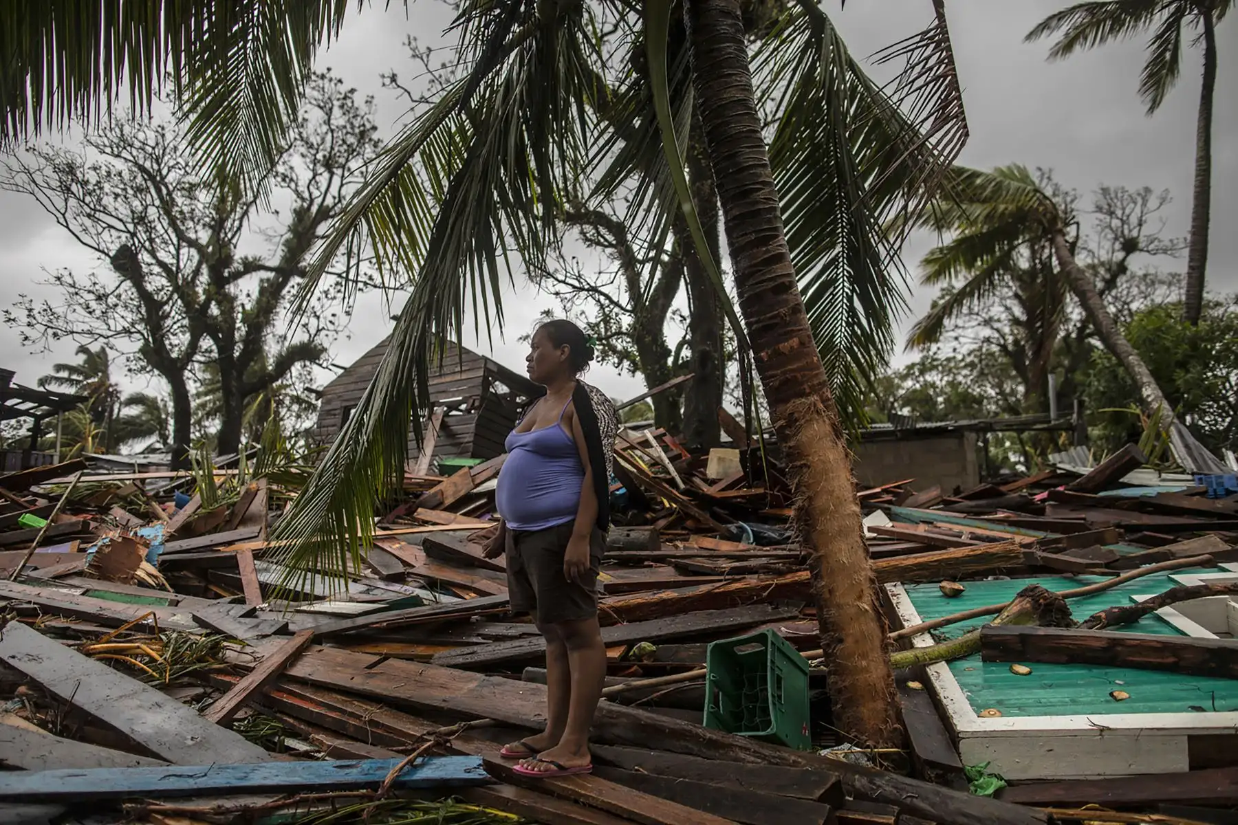 Una mujer espera a que la ayuden a rescatar pertenencias de su casa destruida luego del paso del huracán Iota, en Bilwi, Puerto Cabezas. Foto: AFP