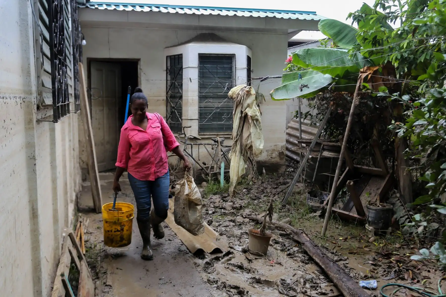 Una mujer evacua su casa, que resultó dañada tras el paso del huracán, en La Lima, Honduras. Foto: AFP