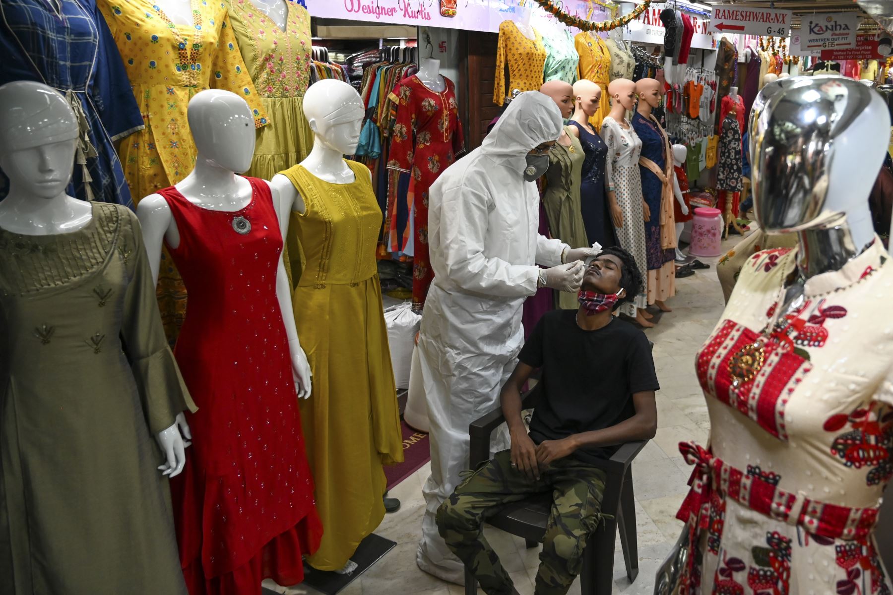 Un trabajador de la salud que usa equipo de protección toma una muestra de hisopo de un hombre durante un examen médico para el coronavirus  en un mercado mayorista de ropa en Mumbai. Los casos de coronavirus en India superaron los nueve millones.
Foto: AFP