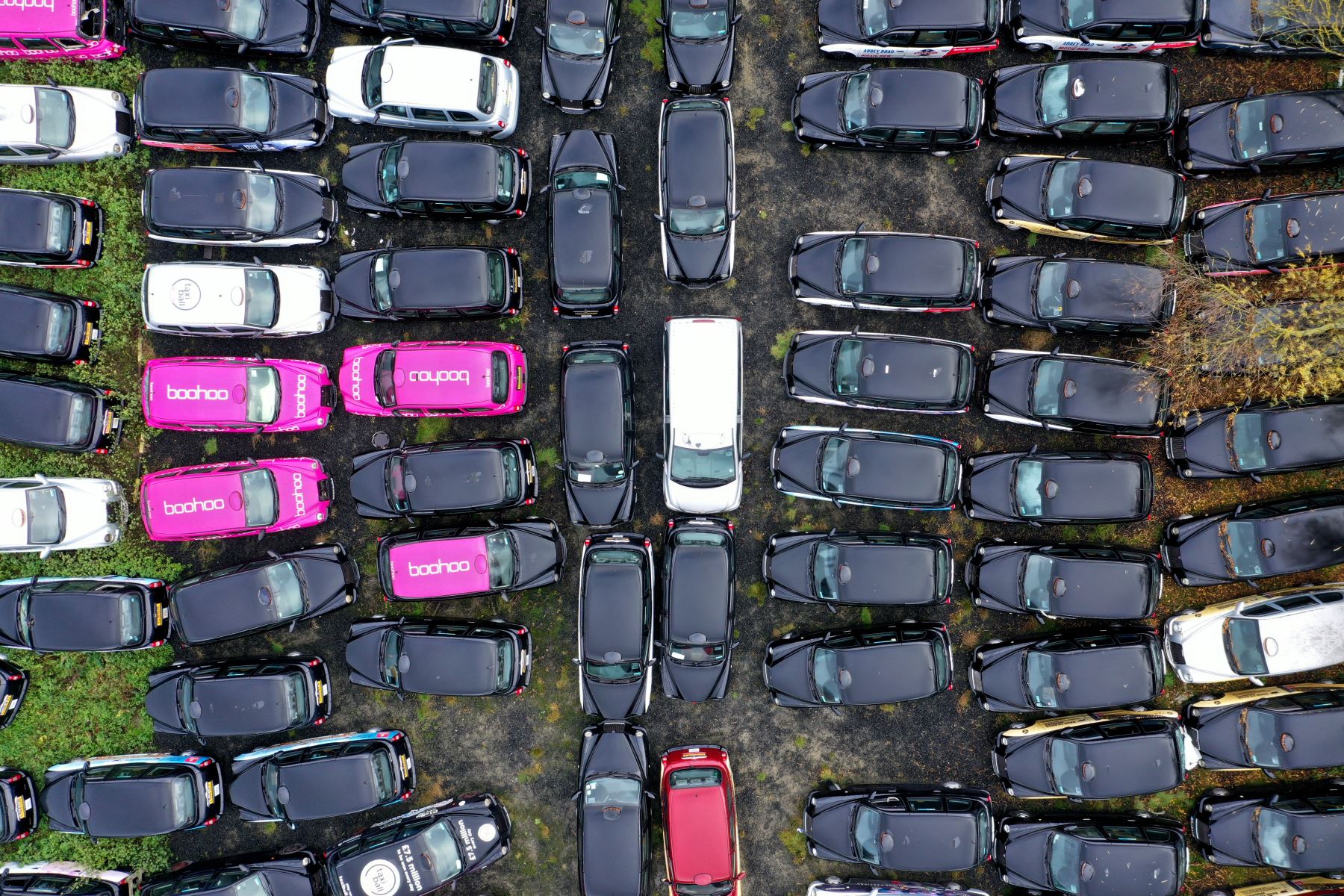 Una vista aérea muestra taxis negros de Londres estacionados en un campo en Epping, al noreste de Londres. Recoger una tarifa se ha vuelto tan difícil para los legendarios taxis negros de Londres que muchos taxis están siendo suspendidos. 
Foto: AFP