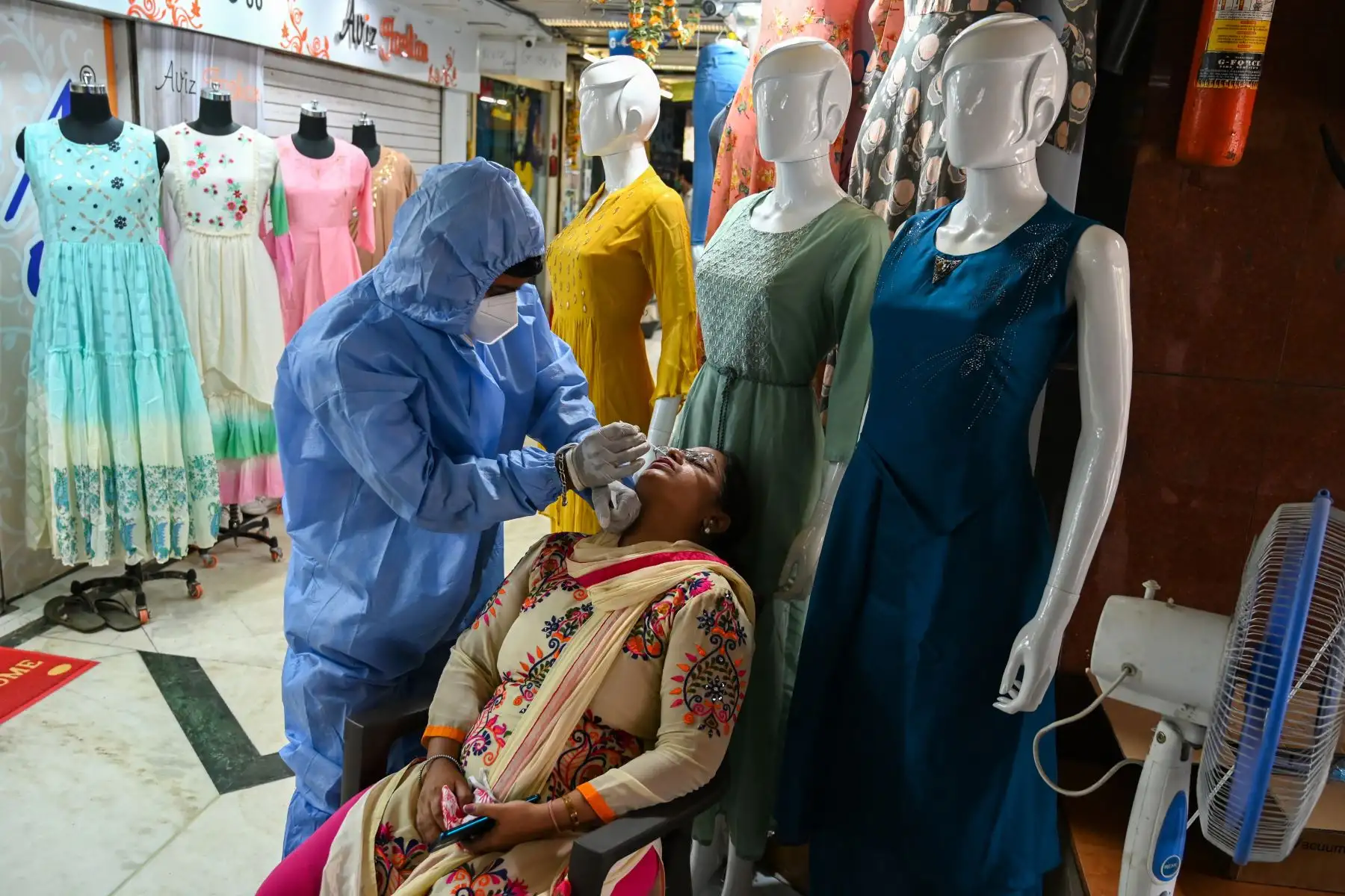 Un trabajador de la salud que usa equipo de protección toma una muestra de hisopo de una mujer durante un examen médico del coronavirus  en un mercado mayorista de ropa en Mumbai. Los casos de coronavirus en India superaron los nueve millones.
Foto: AFP