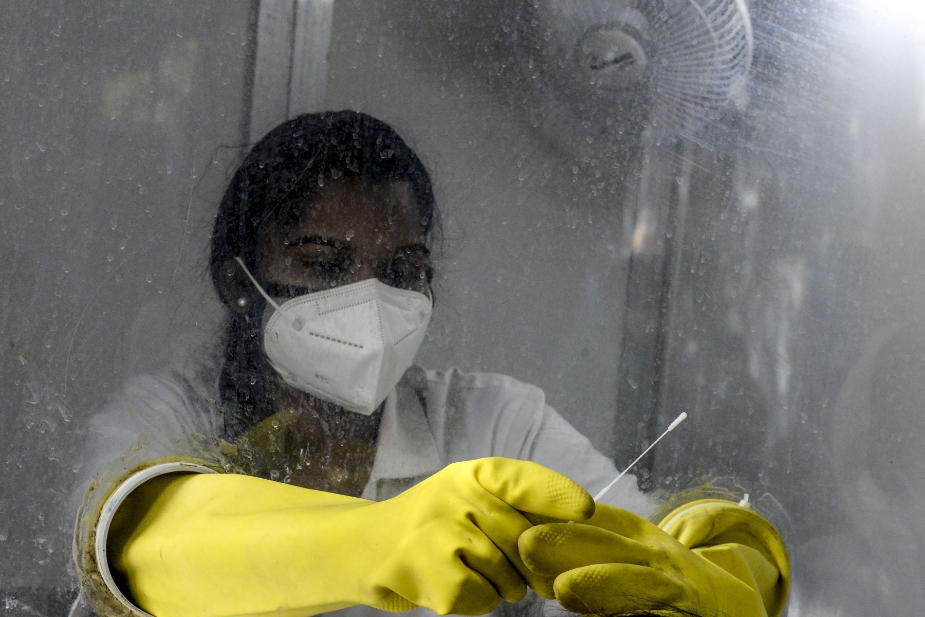 Un trabajador de la salud sostiene un hisopo para recolectar una muestra de un residente a quien se le hizo la prueba del coronavirus  en un centro de salud primario en Hyderabad. El número de casos de coronavirus en India superó los nueve millones.
Foto: AFP