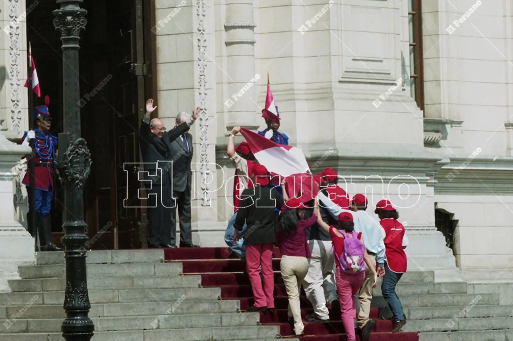 Lima - 24 noviembre 2000. El presidente Valentín Paniagua, se apresta a recibir la bandera peruana de parte del Colectivo Sociedad Civil. El gesto del mandatario generó aplausos de cientos de ciudadanos que se congregaron en la Plaza de Armas de Lima. Foto: Diario Oficial El Peruano / Víctor Palomino