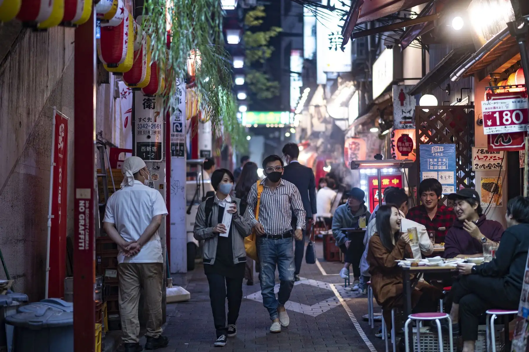 Personas que usan máscaras faciales como medida preventiva ante el coronavirus visitan el área de restaurantes del callejón Omoide Yokocho en el distrito Shinjuku de Tokio. Foto: AFP