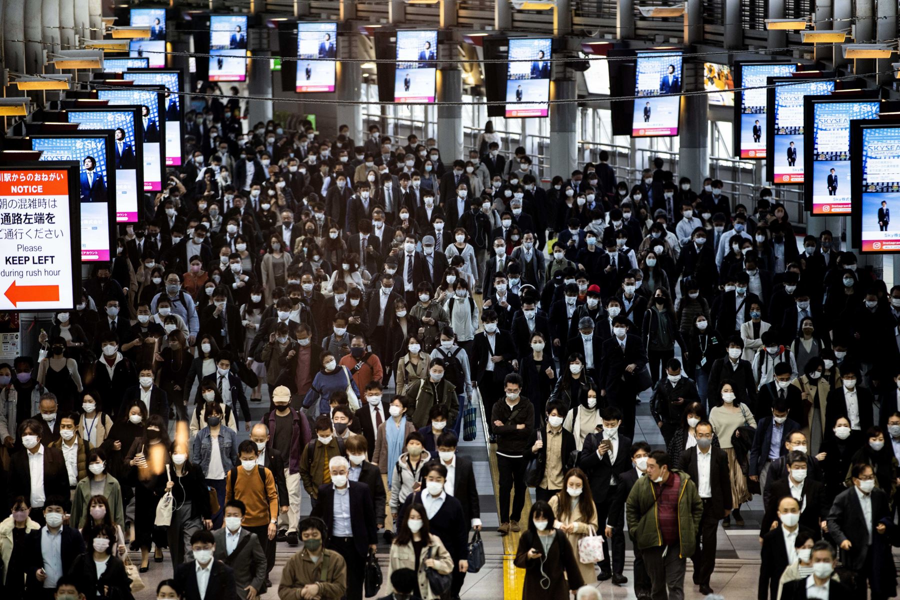 Los viajeros con mascarillas caminan en la estación Shinagawa en Tokio. Foto: AFP