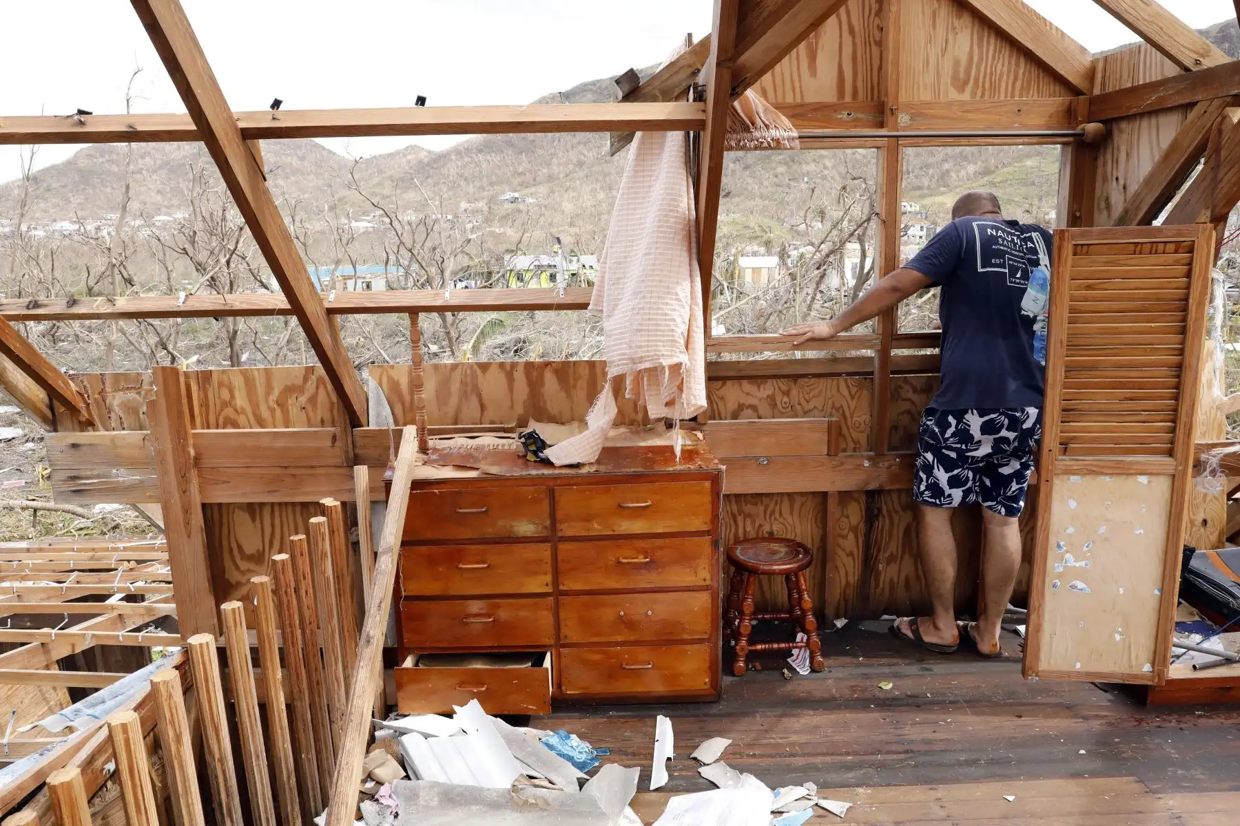 Jeanguillaume Misas se asoma a la ventana de su casa, destruida por el paso del huracán Iota en Providencia, Colombia. 
Foto: ANDINA/Difusión