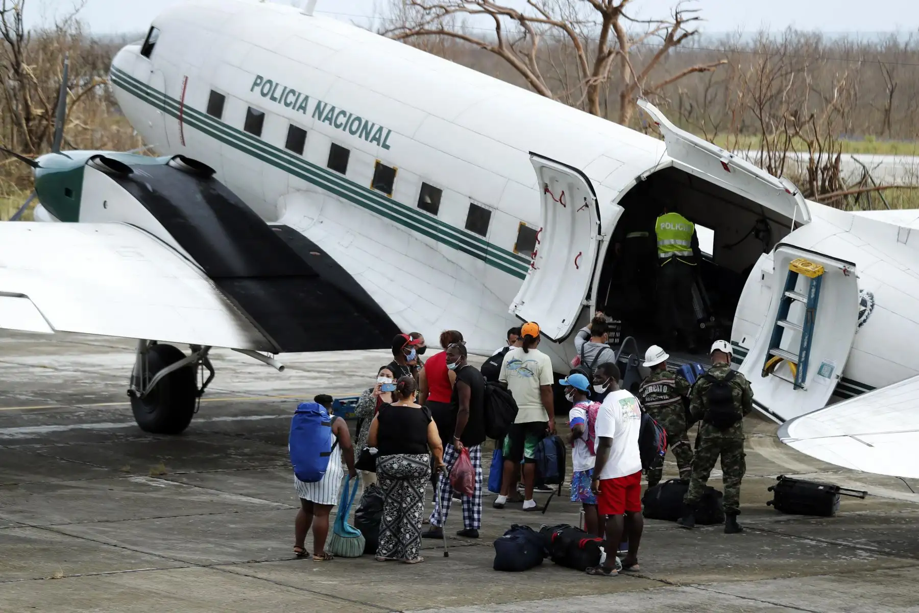 Isleños se preparan para abordar un vuelo humanitarios de la Fuerza Área que parte desde el aeropuerto El Embrujo hacía la isla de San Andrés. Centenares de habitantes de la isla colombiana de Providencia que perdieron todo por el paso del huracán Iota emigran a diario a la de San Andrés.
Foto: AFP