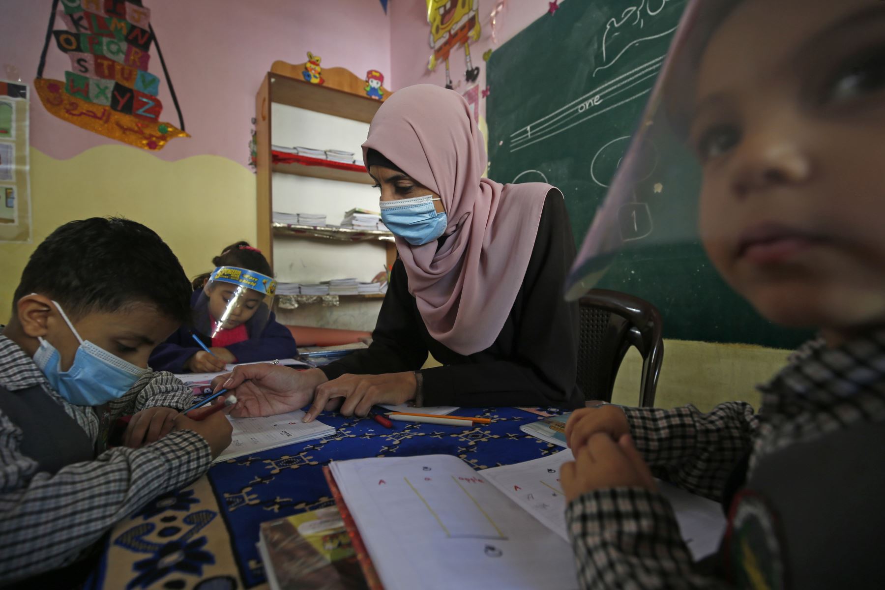 Los niños palestinos participan en una clase con máscaras y protectores faciales debido a la pandemia de Covid-19, en un jardín de infancia en la ciudad de Gaza. Foto: AFP