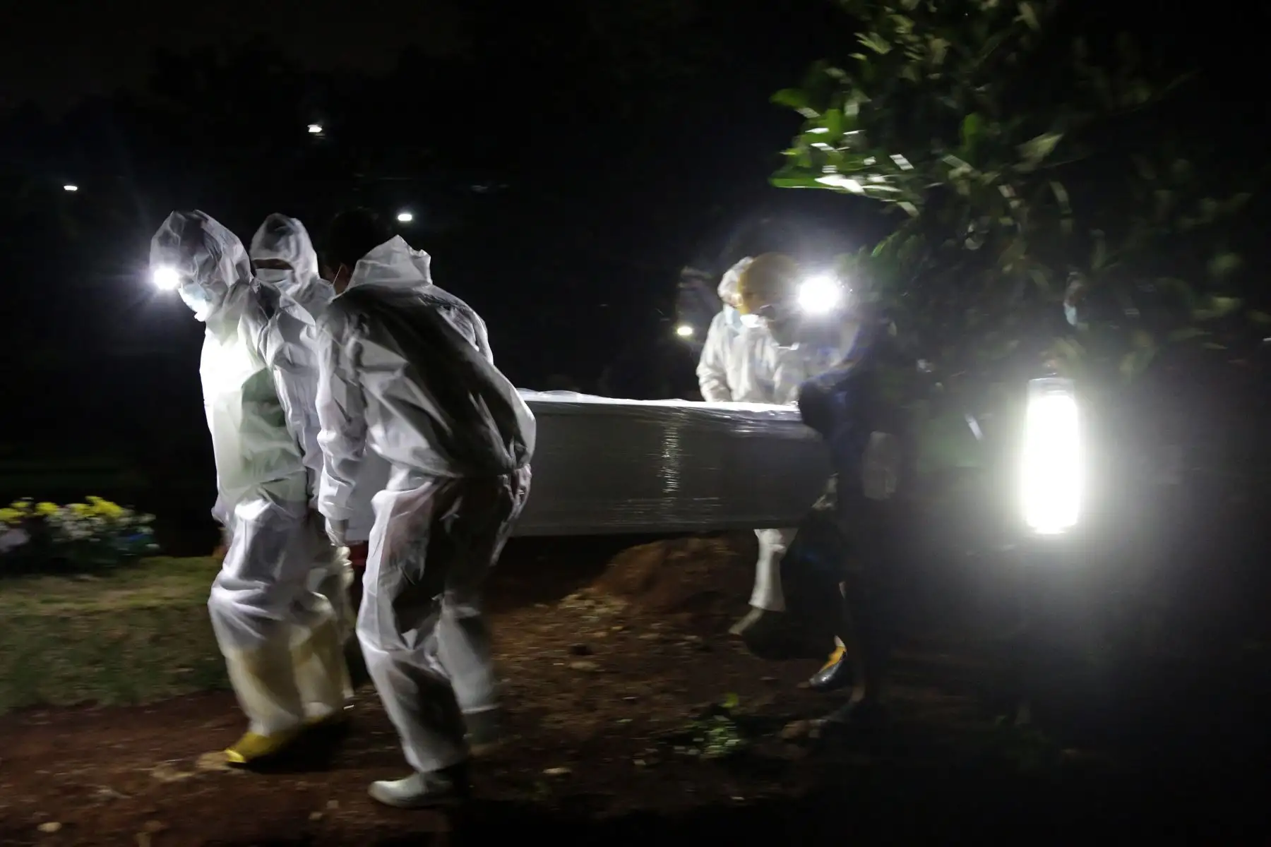 Los sepultureros trasladan un ataúd durante un funeral de una víctima del coronavirus en un cementerio en Bogor, en Indonesia. Foto: AFP