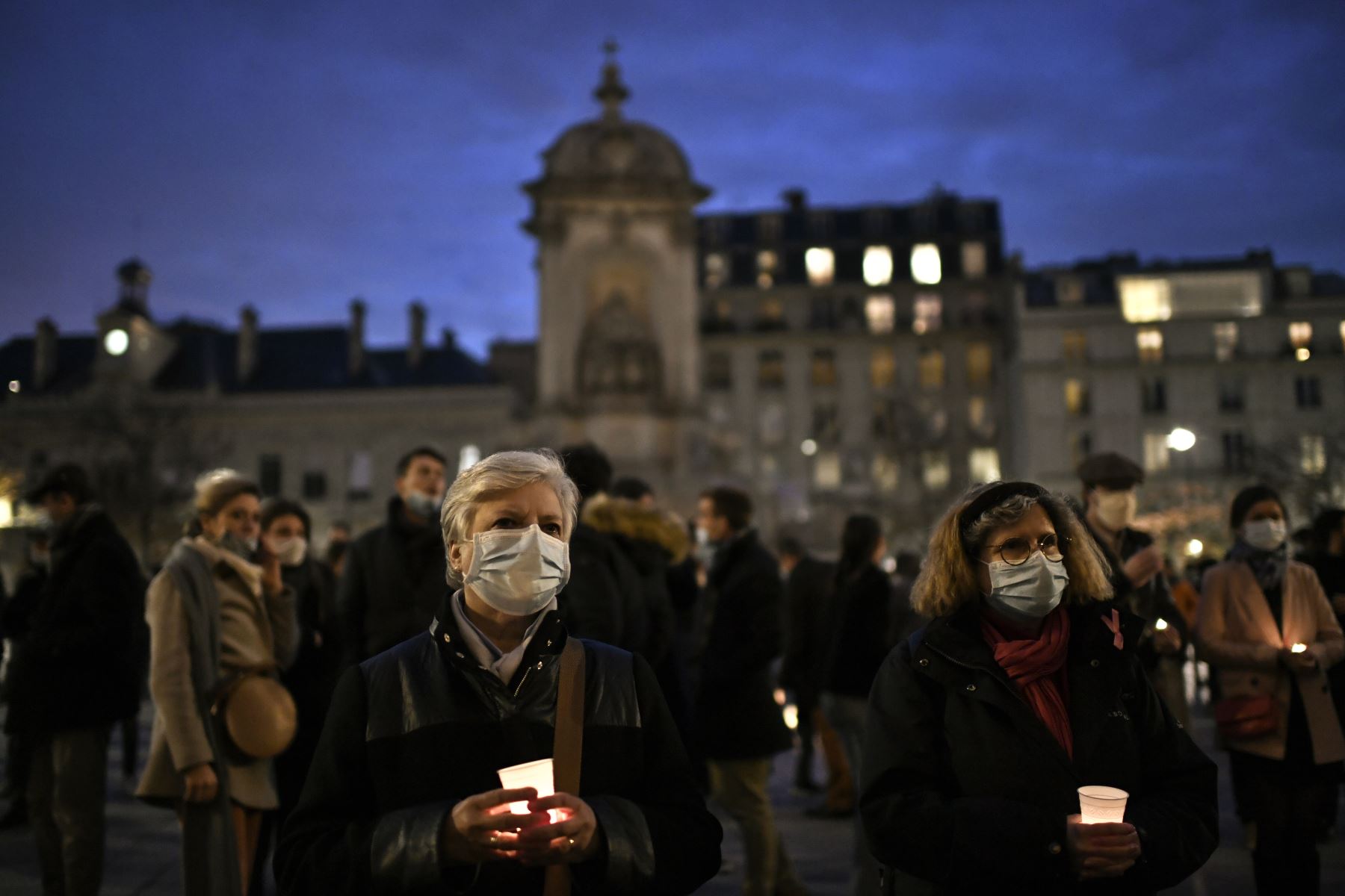 Las personas con velas se reúnen fuera de la iglesia de Saint-Sulpice para protestar contra el cierre de los lugares de culto durante un segundo cierre para frenar la propagación del nuevo coronavirus, en París. Foto: AFP