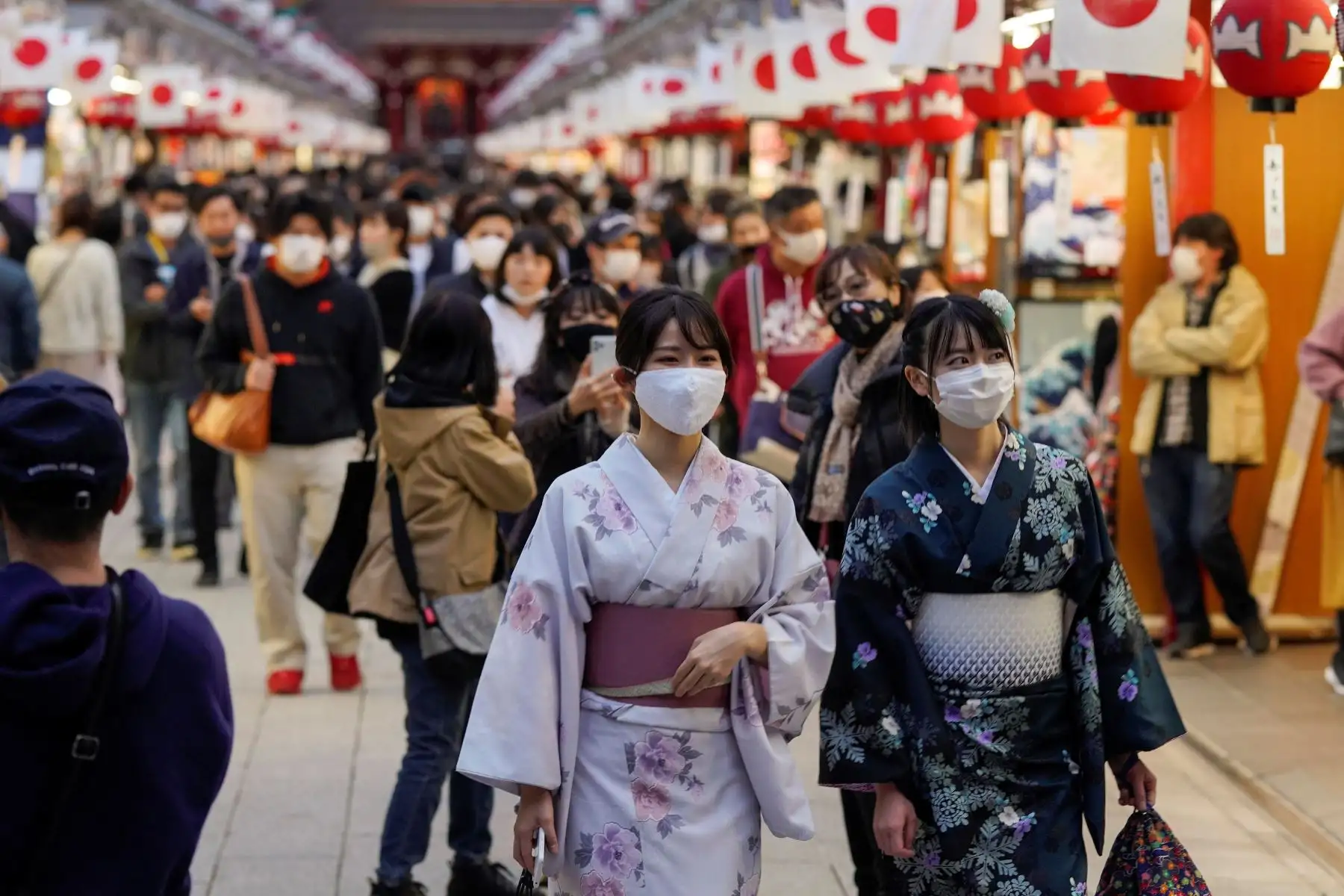 Los turistas disfrutan recorriendo la calle Nakamise decorada con banderas nacionales japonesas en Asakusa, centro de Tokio. Foto: AFP