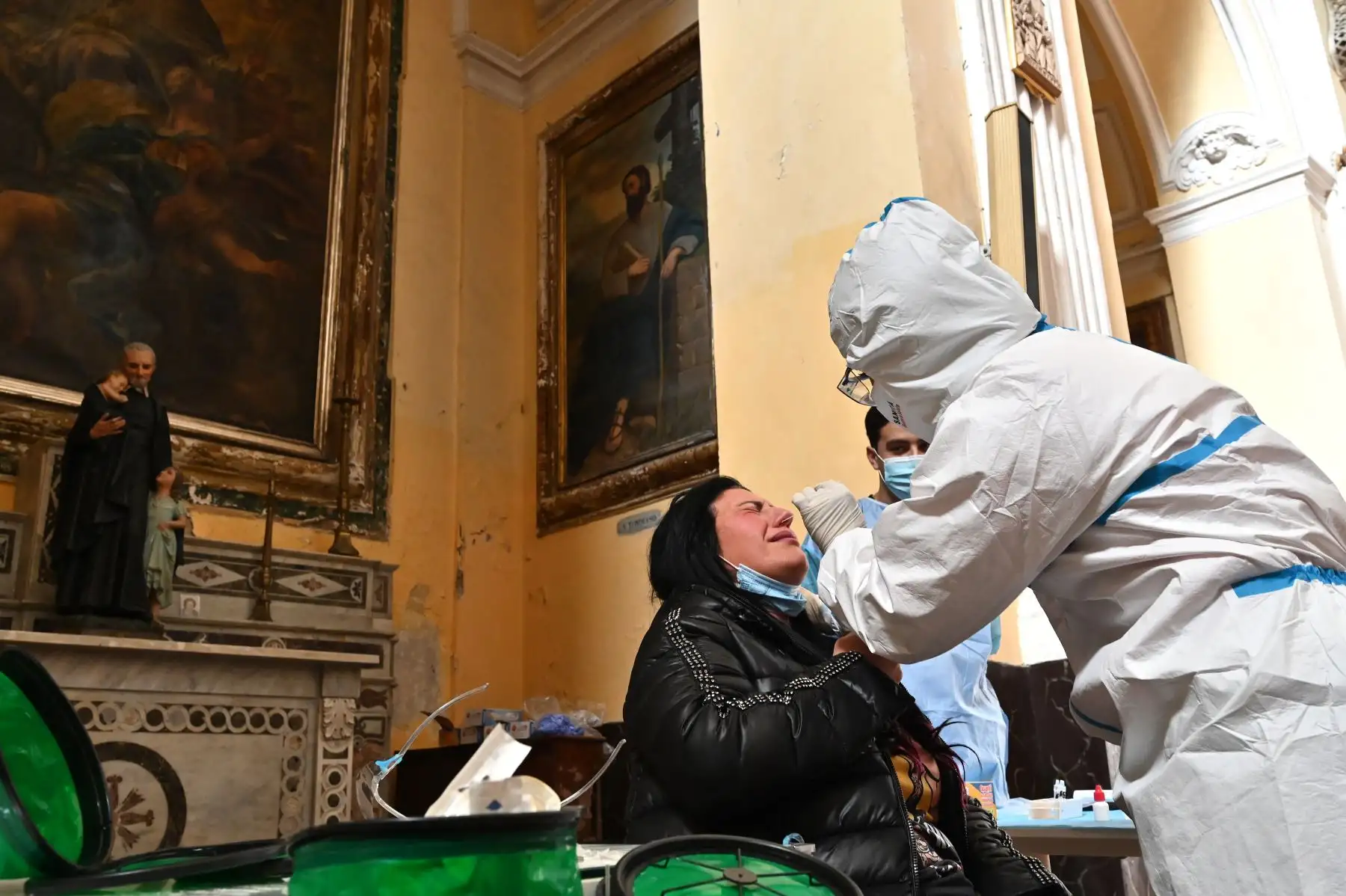 Un trabajador de la salud con equipo de protección personal  toma una muestra de hisopo de una mujer durante una campaña de prueba rápida de antígenos para la enfermedad Covid-19 causada por el nuevo coronavirus, en la Basílica de San Severo en el centro de Nápoles.
Foto: AFP