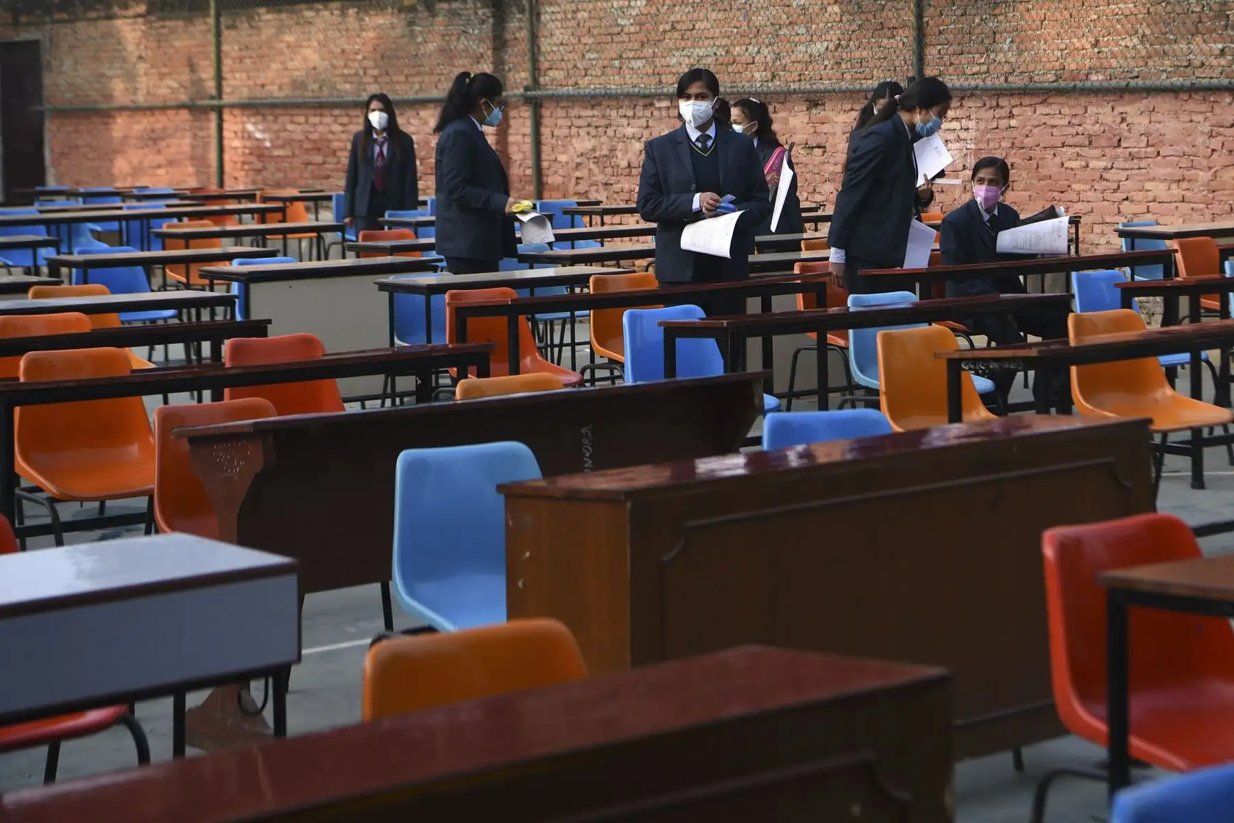 Estudiantes que usan mascarillas rinden el examen en el patio de la escuela en medio de la pandemia del Covid-19 en Katmandú. Foto: AFP