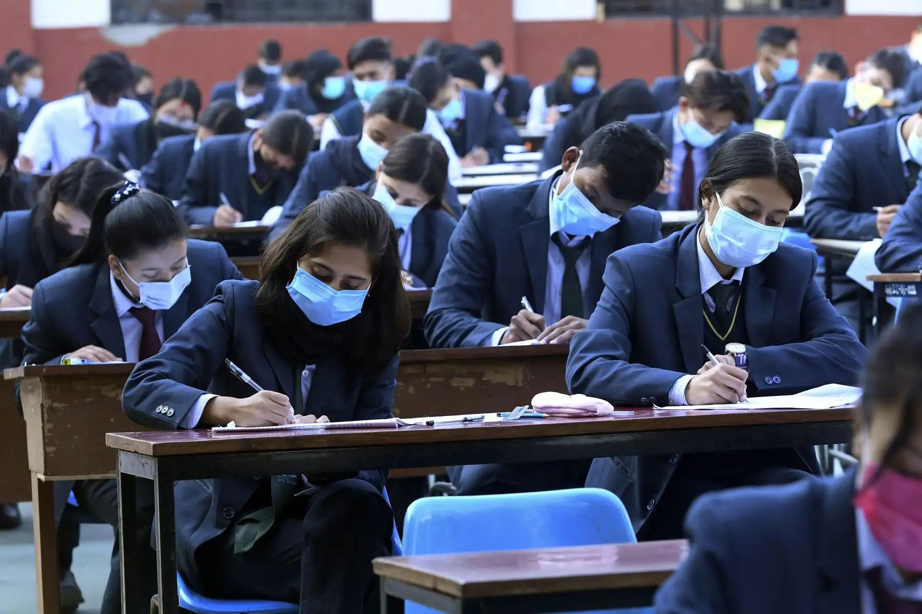 Estudiantes que usan mascarillas rinden el examen en el patio de la escuela en medio de la pandemia del Covid-19 en Katmandú. Foto: AFP