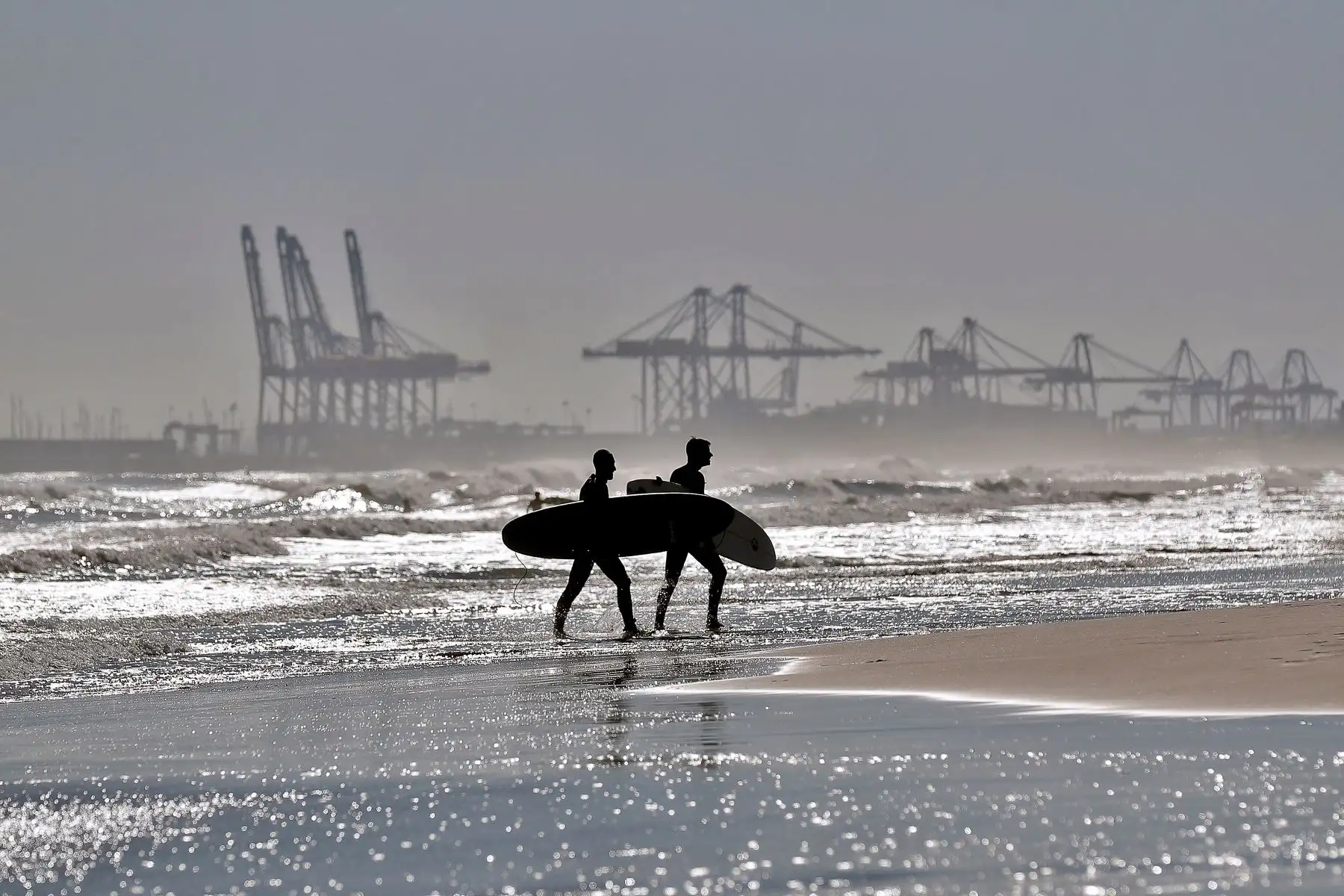 Dos surfistas en la playa de La Malvarrosa de Valencia donde las olas y el cielo despejado han animado a muchos practicar este deporte. Foto: EFE