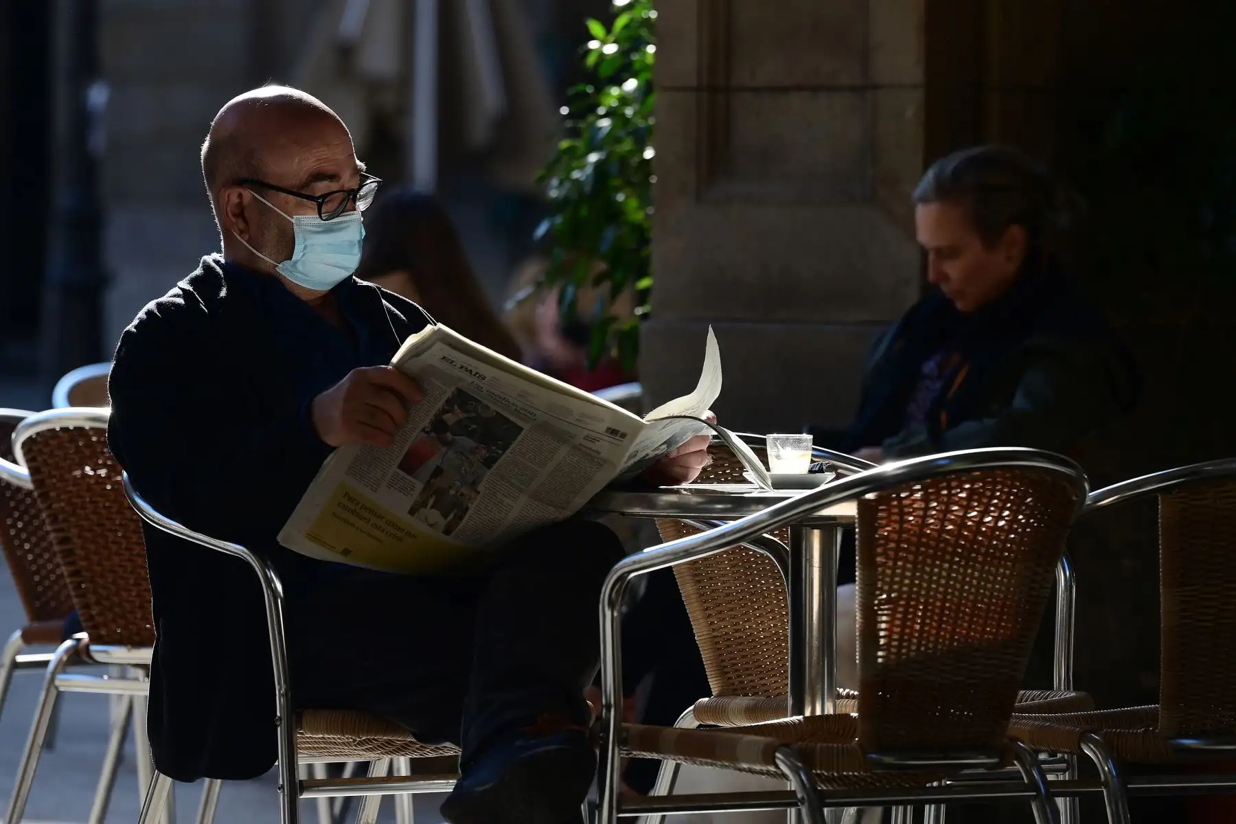 Un hombre lee un periódico en un restaurante de Barcelona mientras se permitía la reapertura de bares, restaurantes y cines en la región nororiental española de Cataluña. Foto: AFP