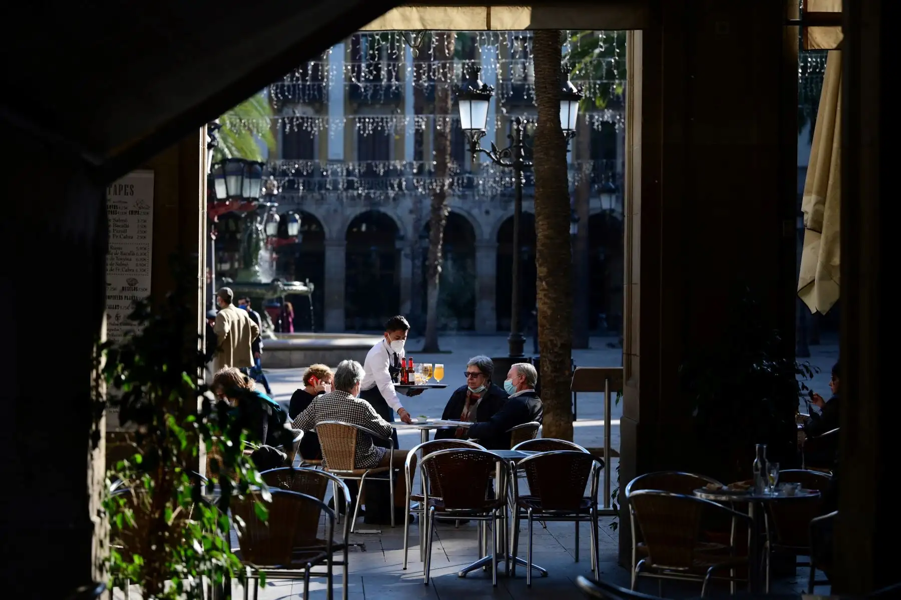 Un camarero atiende a los clientes en un restaurante de Barcelona cuando se permitió la reapertura de bares, restaurantes y cines en la región nororiental española de Cataluña. Foto: AFP