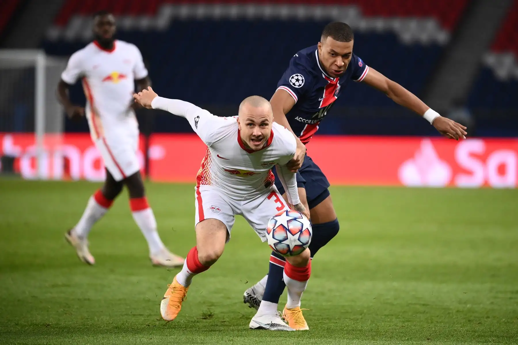 El delantero francés del Paris Saint-Germain Kylian Mbappé compite por el balón con el defensor español del Leipzig Angelino durante el Grupo H de la Liga de Campeones de la UEFA. Foto: AFP