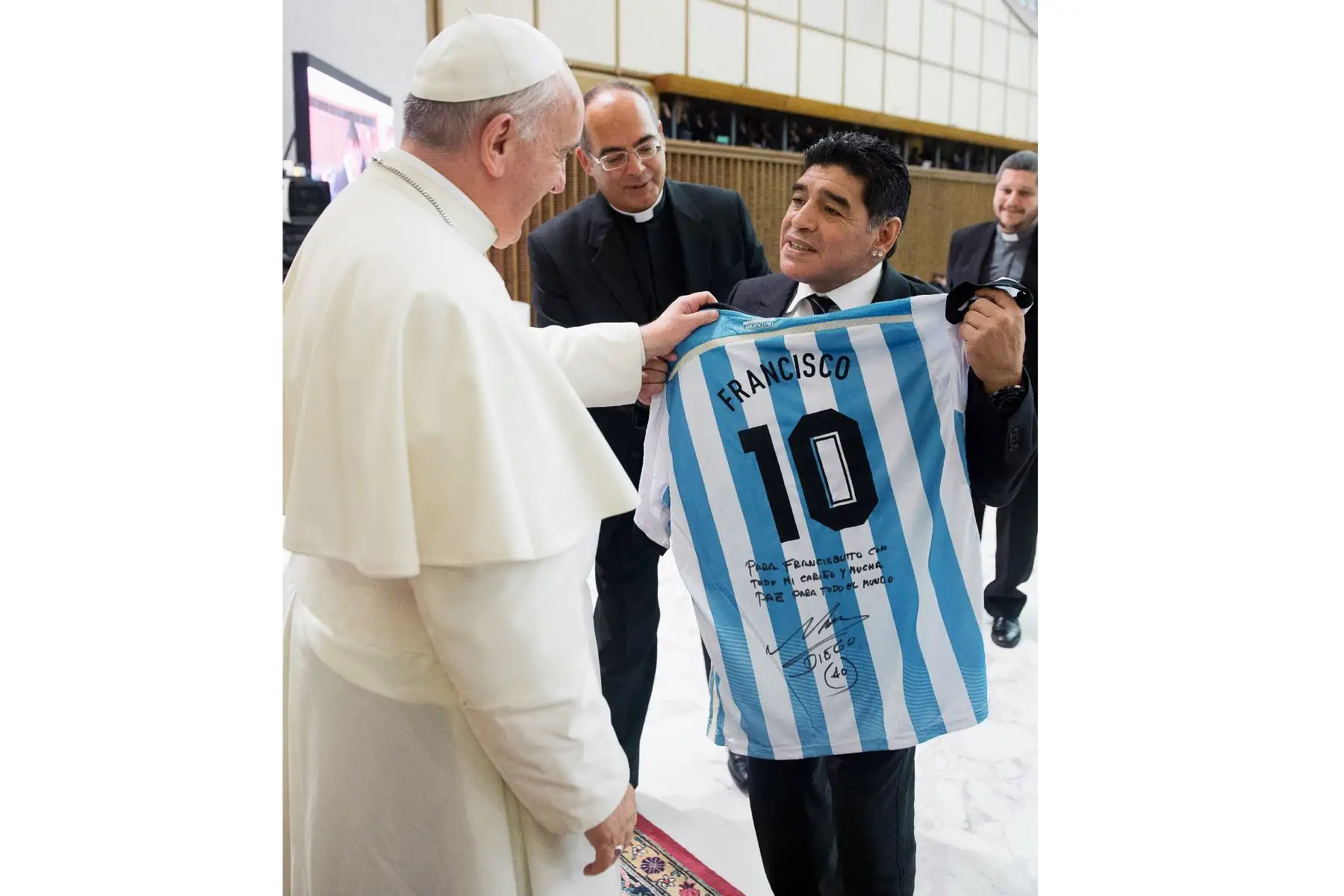 Esta fotografía tomada y publicada el 1 de septiembre de 2014 por el Osservatore Romano, la oficina de prensa del Vaticano, muestra al exfutbolista argentino Diego Armando Maradona presentando una camiseta personalizada de Argentina al Papa Francisco. Foto: AFP