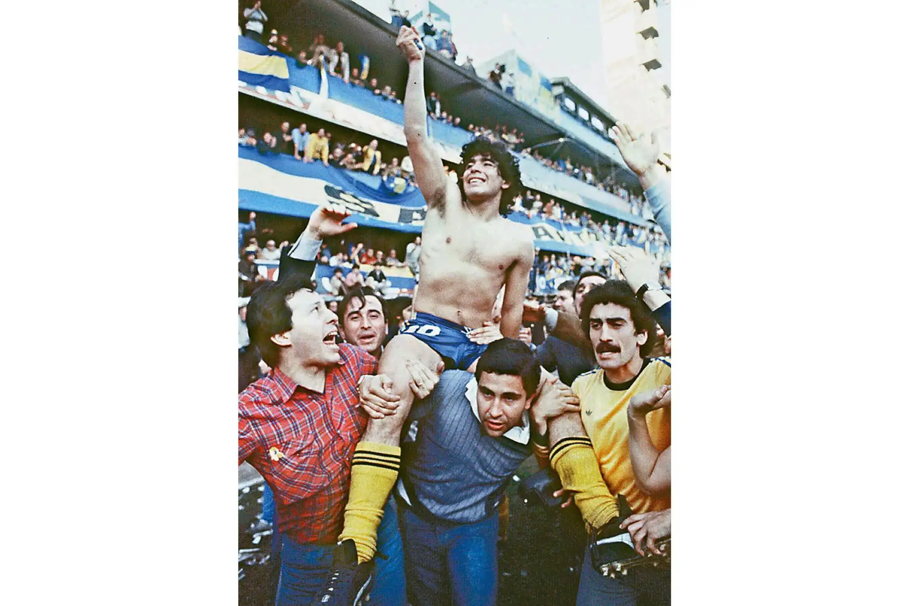 Esta imagen de 1981 muestra al astro del fútbol argentino Diego Armando Maradona, siendo llevado por fanáticos después de ganar el Campeonato local de 1981 con Boca Juniors en el estadio La Bombonera de Buenos Aires. Foto: AFP