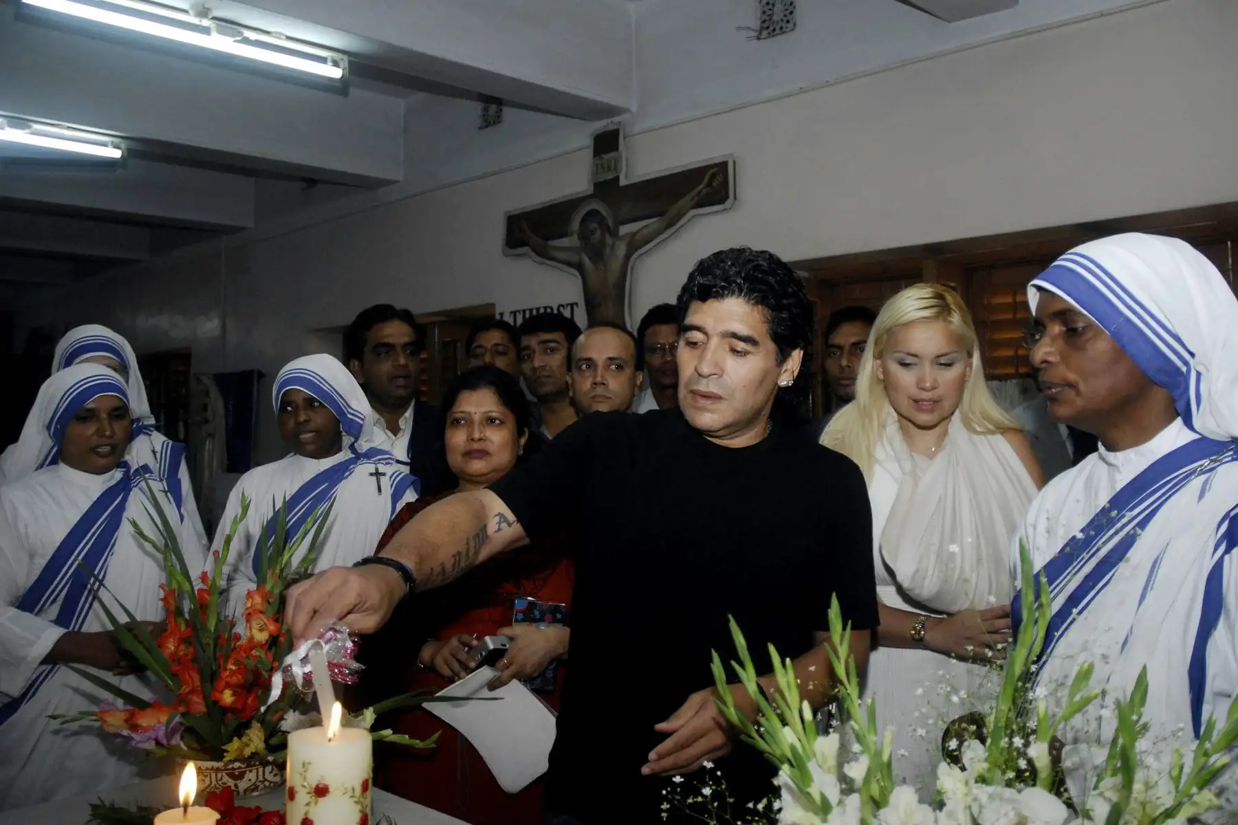 El entrenador de la selección nacional de fútbol de Argentina y ex estrella del fútbol Diego Armando Maradona enciende una vela mientras su novia Verónica observa junto con las monjas de la orden de las Misioneras de la Caridad de la Madre Teresa en Calcuta, el 7 de diciembre de 2008, en la India. Foto: AFP
