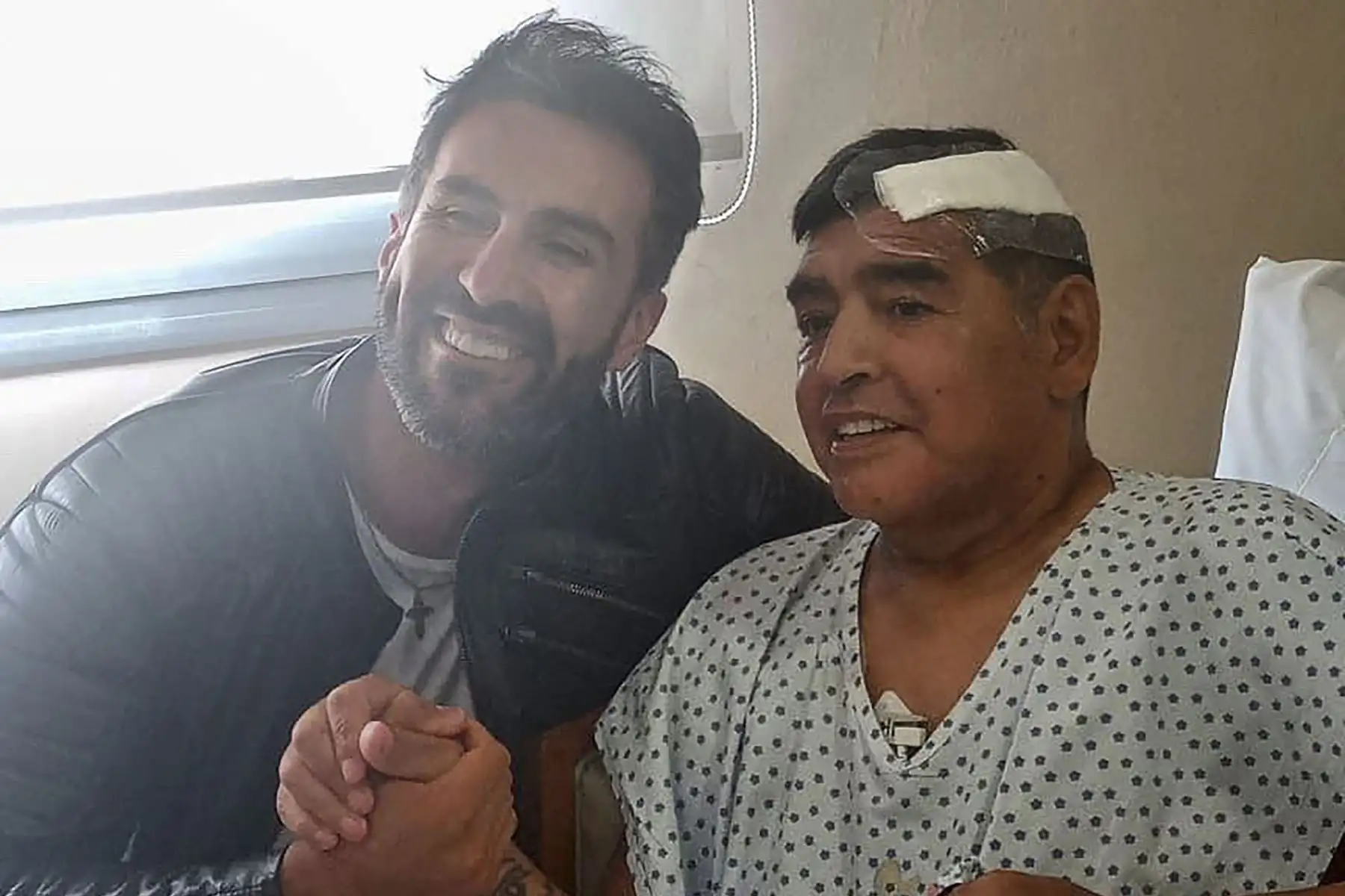 Esta fotografía de archivo del folleto tomada el 11 de noviembre de 2020 y publicada por el oficial de prensa de Diego Armando Maradona muestra a la leyenda del fútbol argentino estrechando la mano de su médico Leopoldo Luque, en Olivos, provincia de Buenos Aires. Foto: AFP