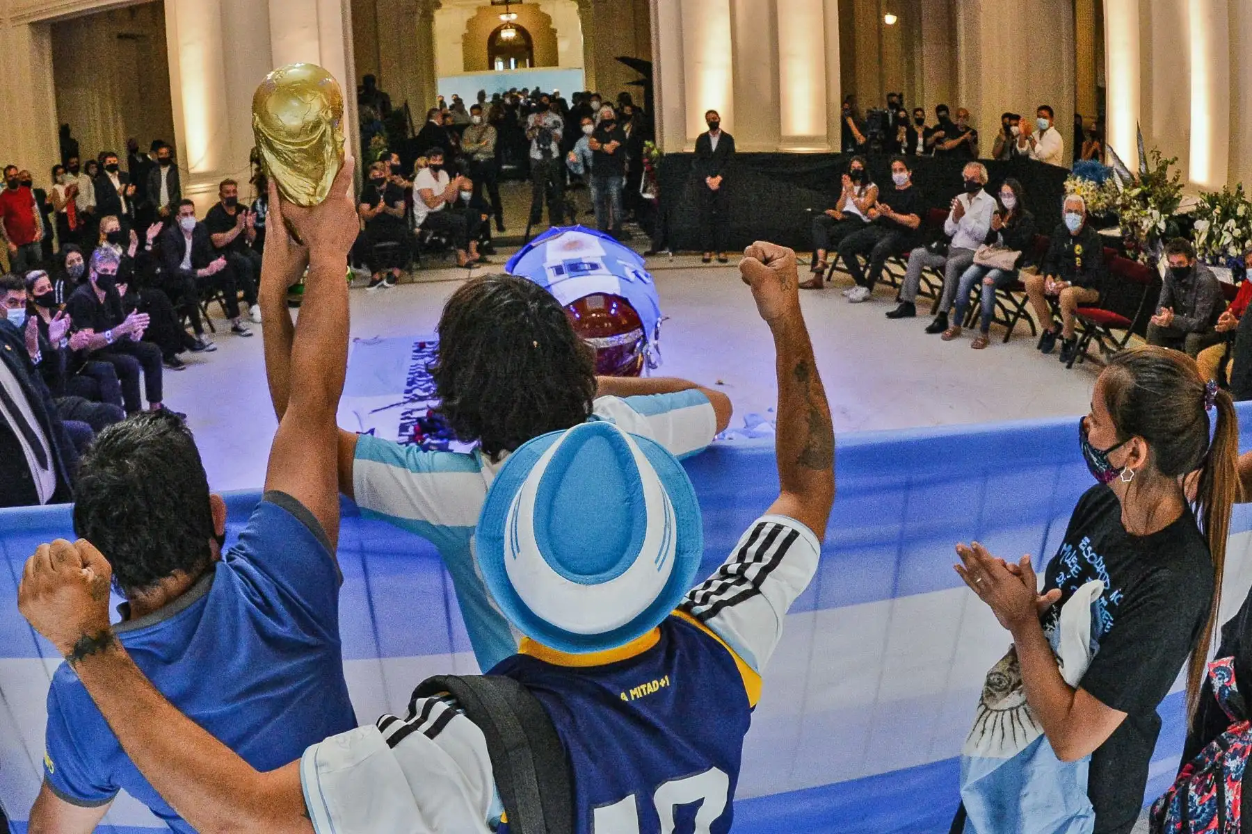 Hinchas que rinden homenaje al ataúd de la leyenda del fútbol argentino Diego Maradona en la capilla del palacio presidencial de la Casa Rosada en Buenos Aires. Foto: AFP