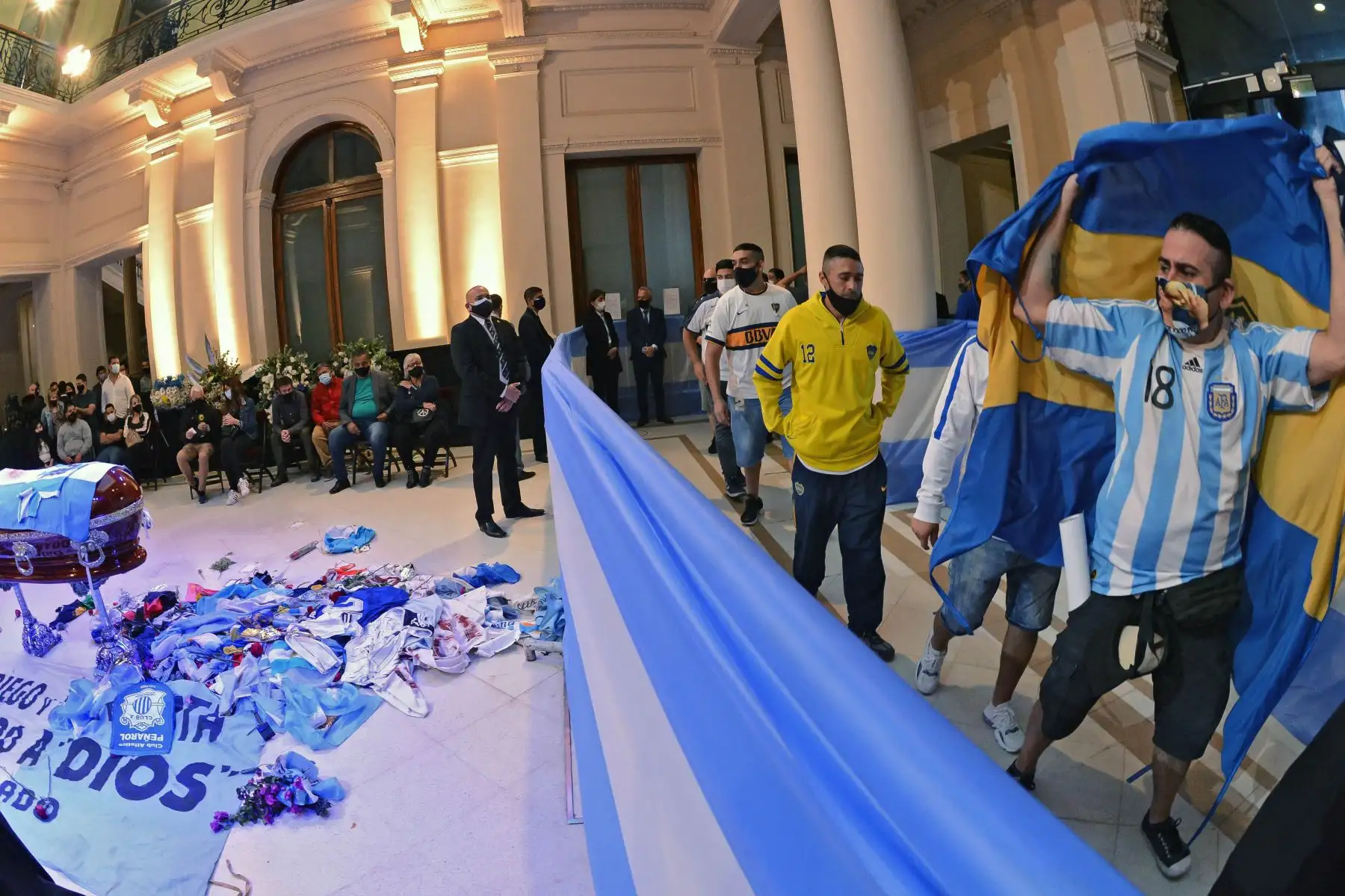 Hinchas que rinden homenaje al ataúd de la leyenda del fútbol argentino Diego Maradona en la capilla del palacio presidencial de la Casa Rosada en Buenos Aires. Foto: AFP