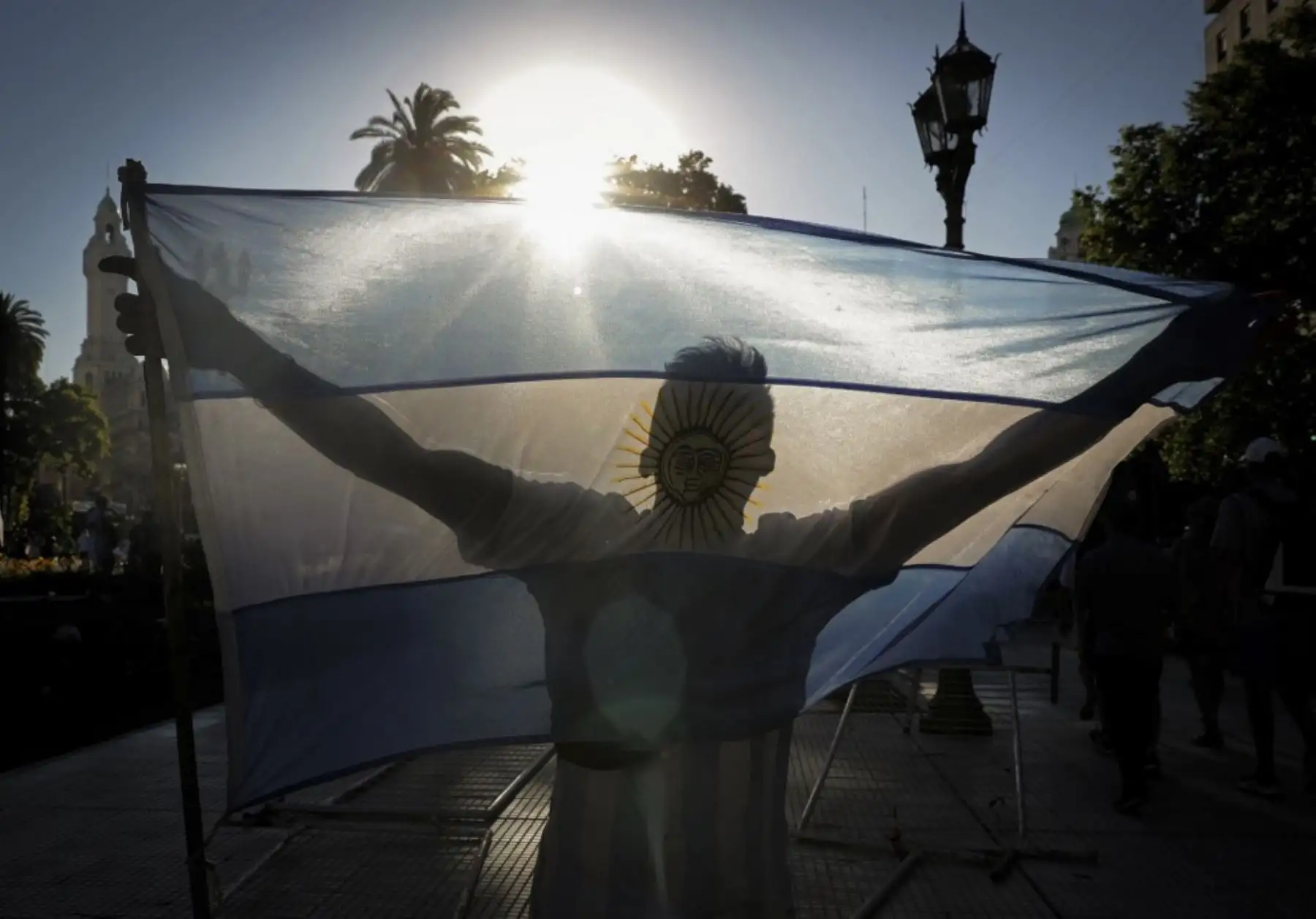 Un fanático de la leyenda del fútbol argentino Diego Armando Maradona sostiene una bandera argentina en la Plaza de Mayo frente al palacio presidencial Casa Rosada donde tuvo lugar el velorio de Maradona, en Buenos Aires. Foto: AFP