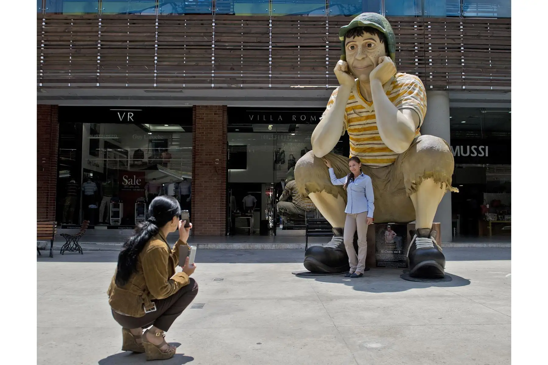 Una mujer toma una fotografía de la escultura del famoso personaje de la televisión latinoamericana "El Chavo del Ocho" exhibida en el Mall Chipichape, Colombia. Foto: AFP
