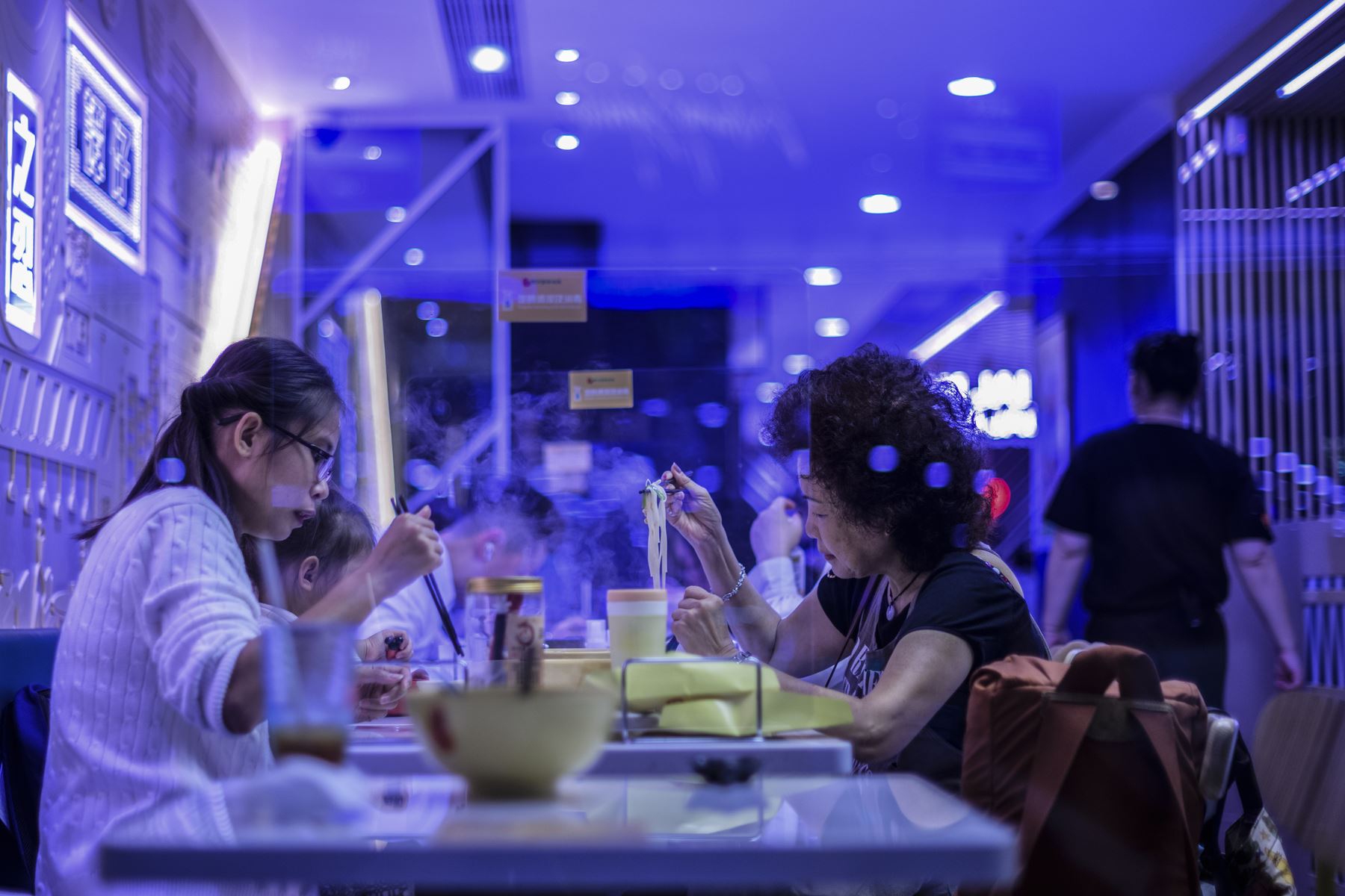 La gente come en un restaurante que implementó escudos de protección entre las mesas para mantener la distancia social y disminuir así los contagios Covid-19, en Hong Kong. Foto: AFP