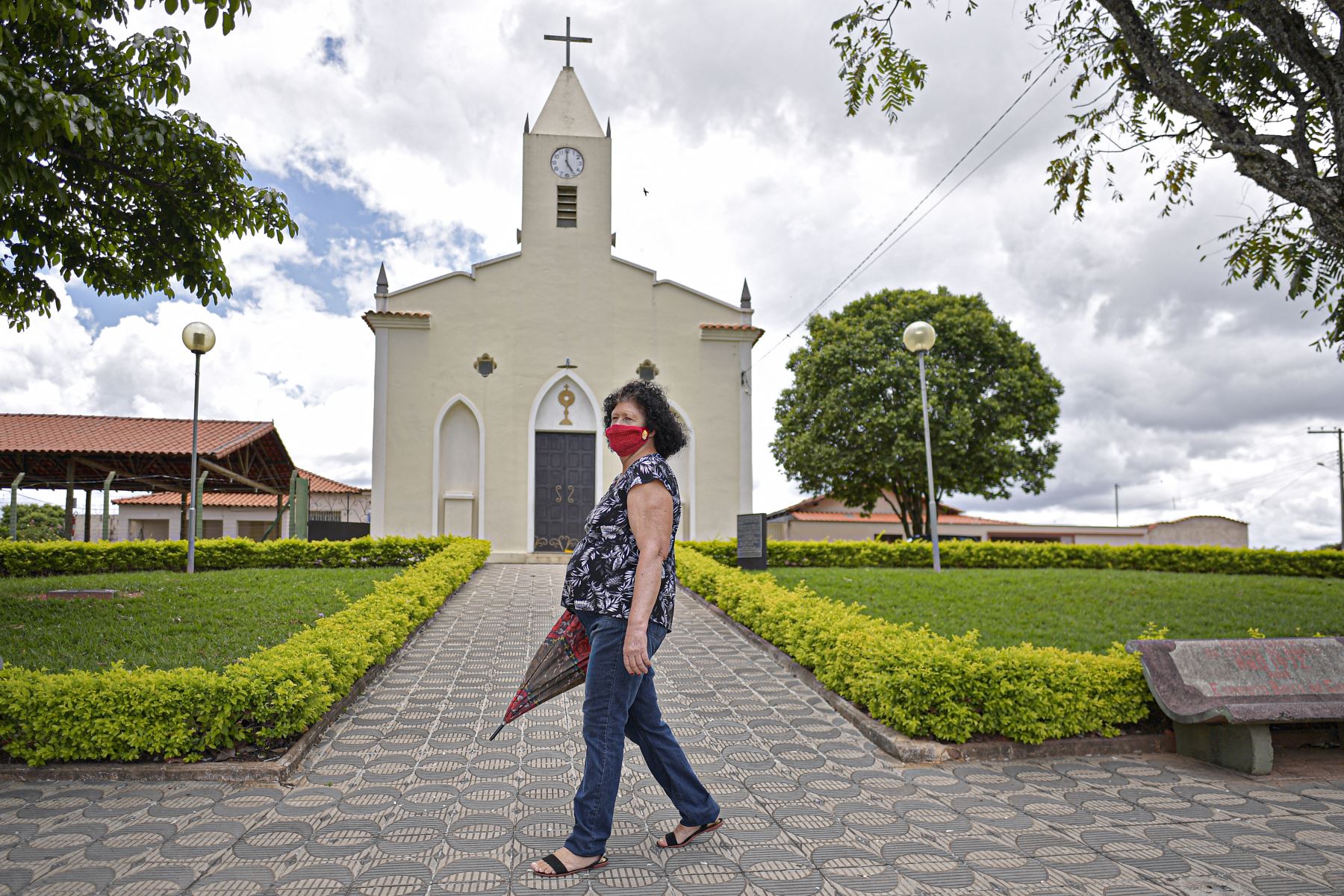 Una mujer camina frente a la iglesia en Cedro do Abaete, localidad con una población de 1210 habitantes, en el estado de Minas Gerais, la única ciudad de Brasil que aún no ha registrado ningún caso del nuevo coronavirus al 23 de noviembre. Foto: AFP