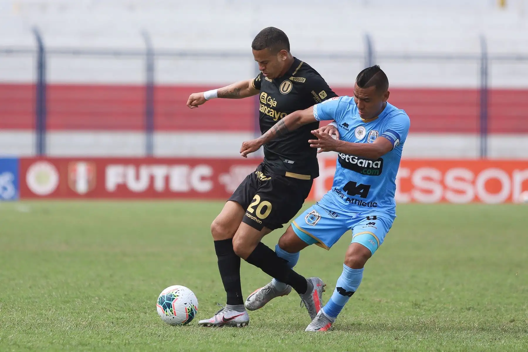D. Millán de Universitario se enfrenta por el balón ante su rival de Binacional durante partido por la última fecha de la fase 2 de la Liga 1, en el estadio Ivan Elías Moreno. Foto: Liga 1