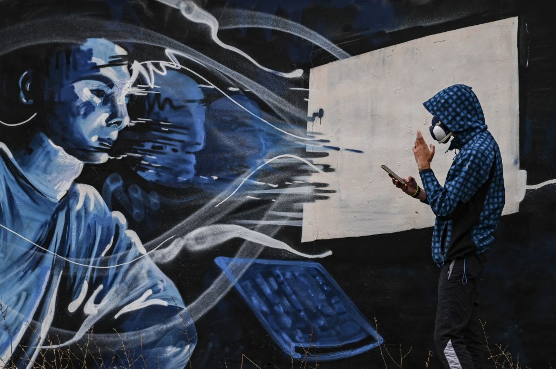 El artista callejero SF pinta un mural en una pared, inspirado en el segundo encierro en Grecia debido a la pandemia covid-19 en Atenas. Foto: AFP