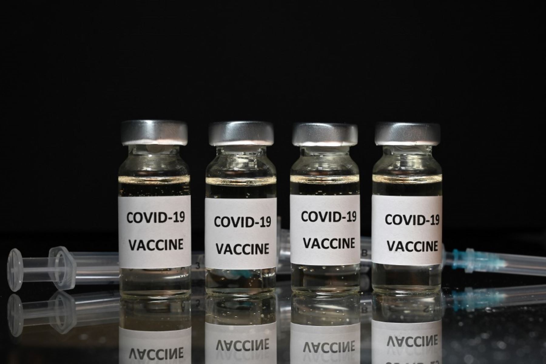 Una imagen ilustrativa muestra viales con adhesivos de la vacuna Covid-19 adheridos y jeringas con el logotipo de la empresa de biotecnología estadounidense Novavax. Foto: AFP