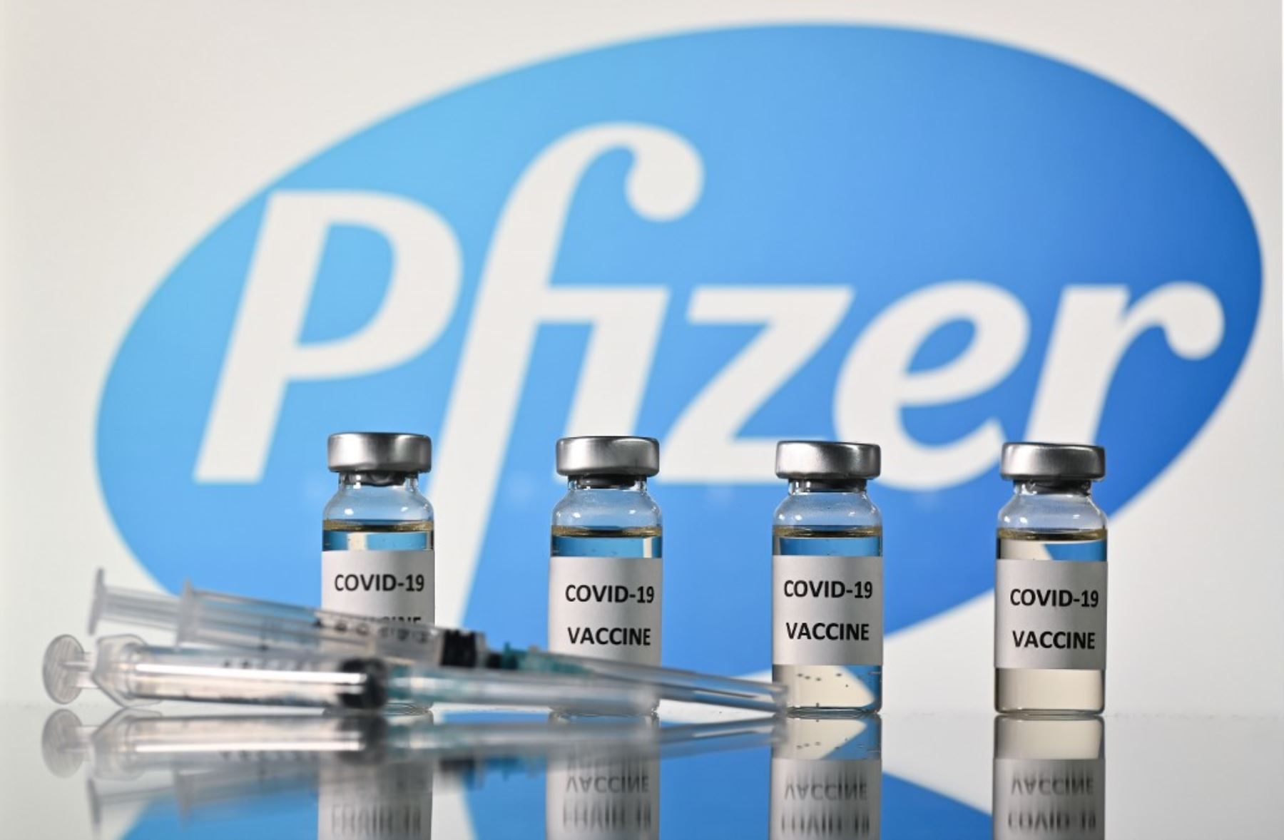 Una imagen ilustrativa muestra viales con adhesivos de vacuna Covid-19 adheridos y jeringas con el logotipo de la compañía farmacéutica estadounidense Pfizer. Foto:AFP
