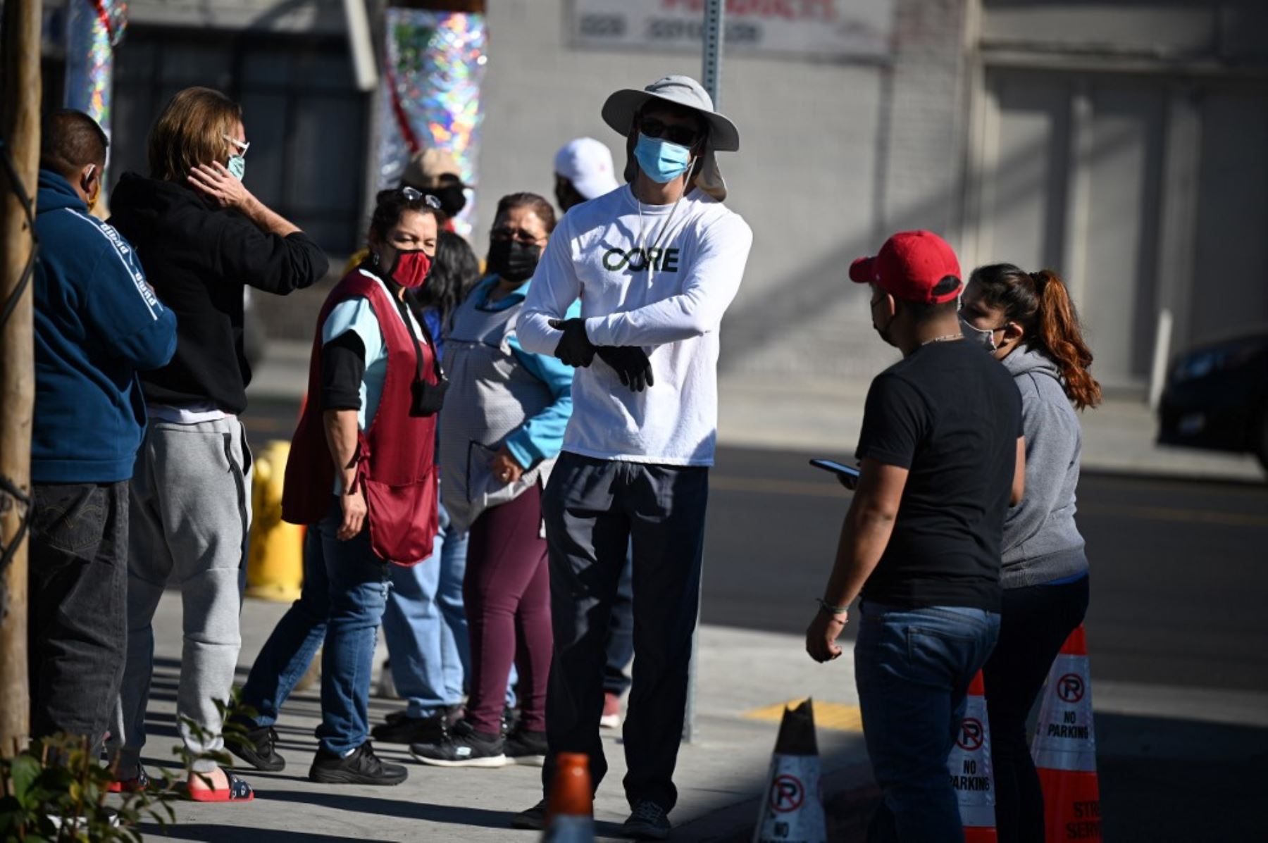 Un trabajador de Community Organized Relief Effort habla con las personas que esperan en la fila para las pruebas de coronavirus en el sur de Los Ángeles, California. Foto:AFP