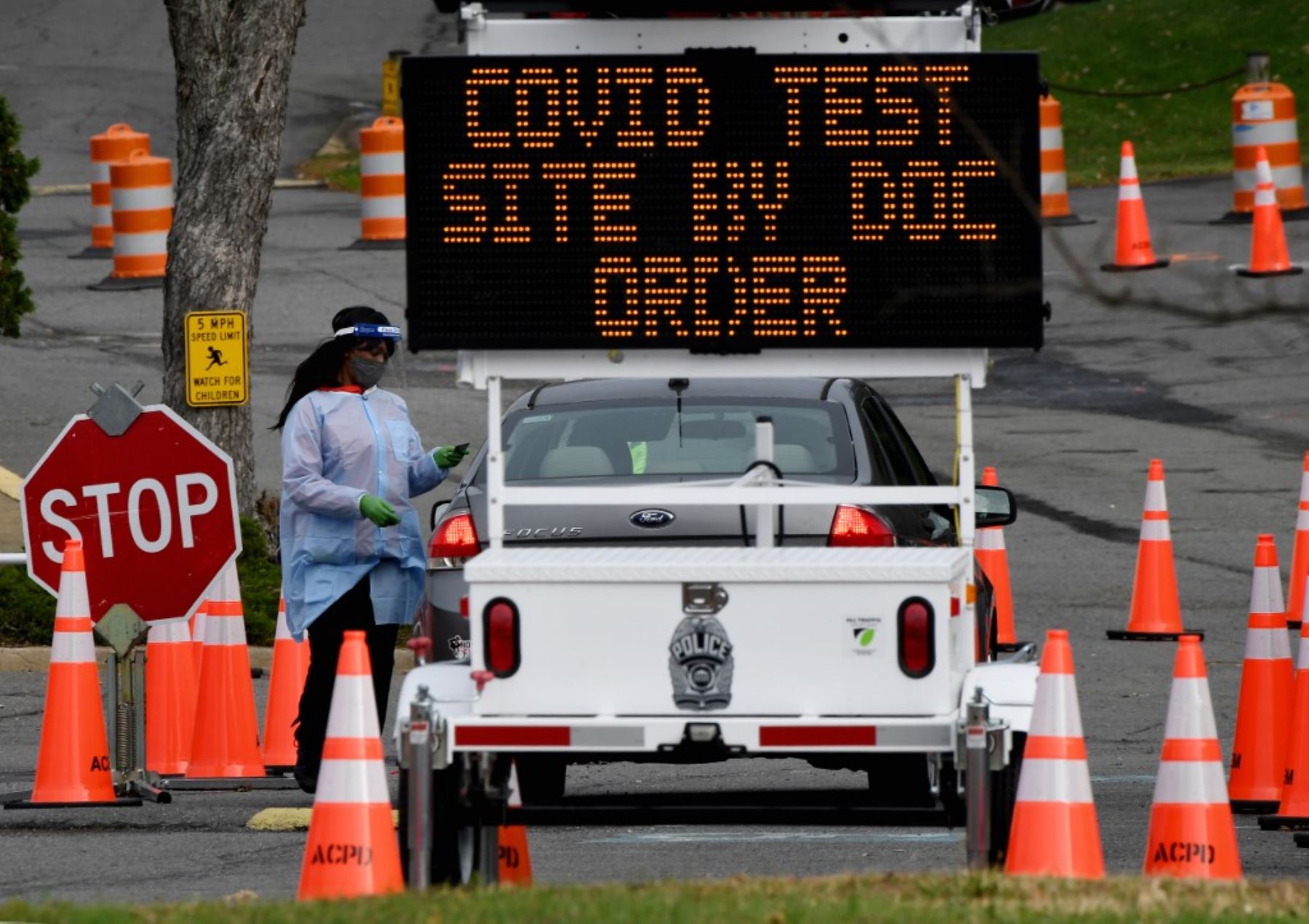 Un trabajador de la salud supervisa los automóviles cuando las personas llegan para hacerse la prueba del coronavirus en un sitio de pruebas en Arlington, Virginia. Foto: AFP