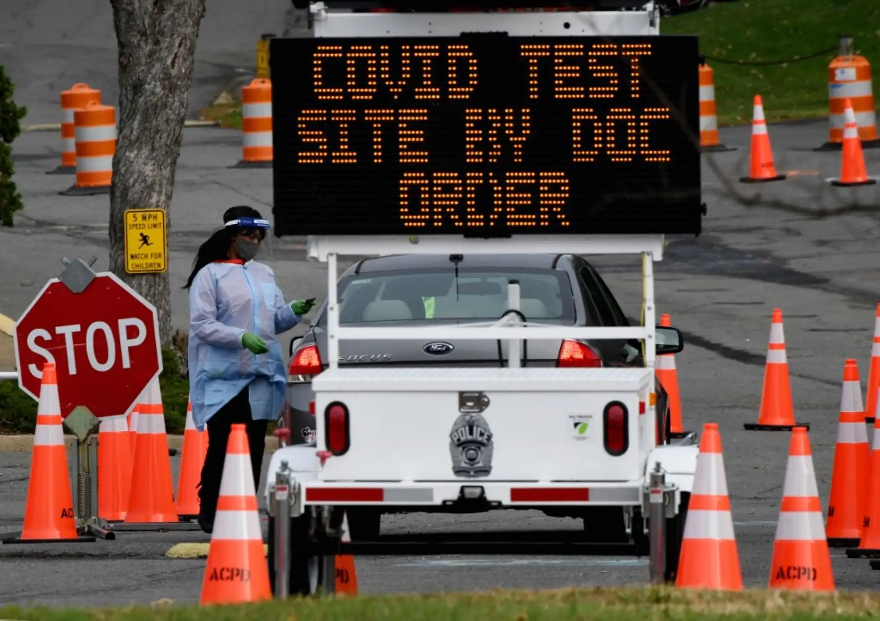 Un trabajador de la salud supervisa los automóviles cuando las personas llegan para hacerse la prueba del coronavirus en un sitio de pruebas en Arlington, Virginia. Foto: AFP