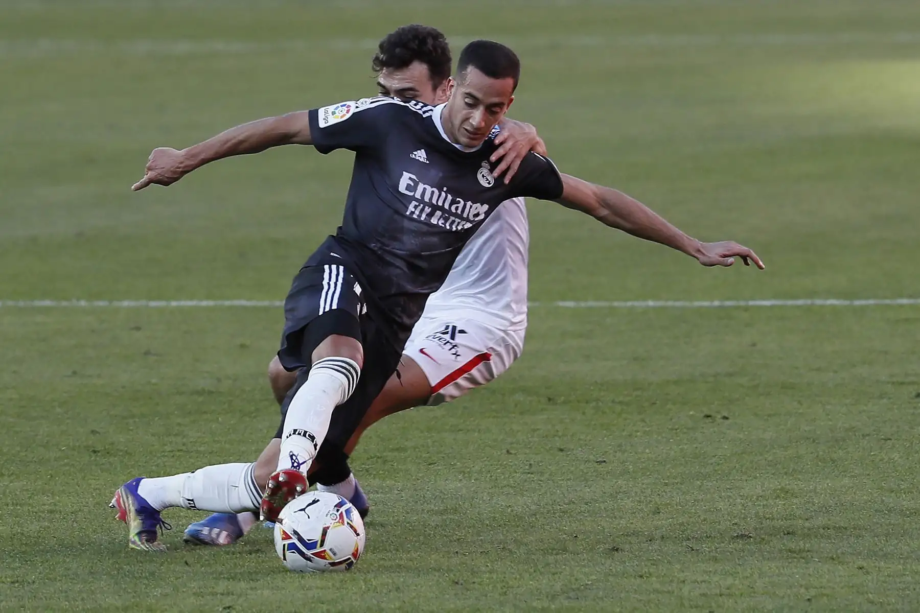 El centrocampista del Sevilla Munir El Haddadi pelea un balón con el defensa del Real Madrid Lucas Vázquez durante el partido de LaLiga disputado este sábado en el estadio Sánchez Pizjuán. Foto: EFE