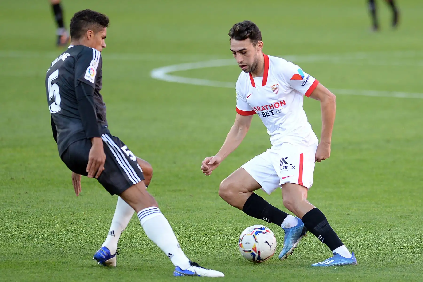 El delantero español del Sevilla, Munir El Haddadi, desafía al defensor francés del Real Madrid, Raphael Varane, durante el partido de fútbol de la Liga española. Foto: AFP